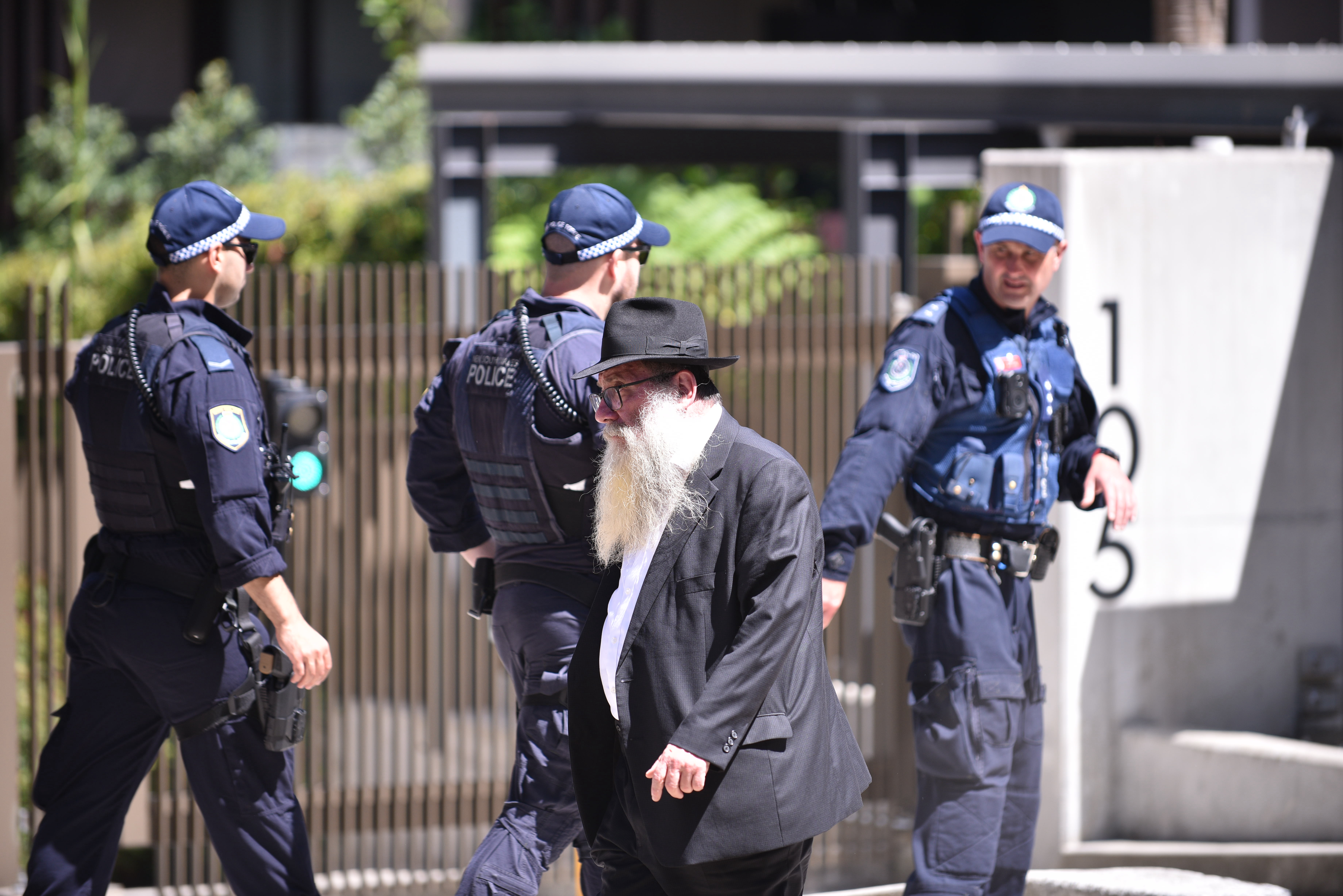 A mourner walks past policemen during the memorial service for Reuven Morrison at Chabad of Bondi Synagogue following a shooting at Bondi Beach, in Sydney, Australia, 17 December 2025. Reuven Morrison is among the 15 people who were killed by the gunmen while attending the Hanukkah celebration at Bondi Beach Park on 14 December. EPA/FLAVIO BRANCALEONE AUSTRALIA AND NEW ZEALAND OUT