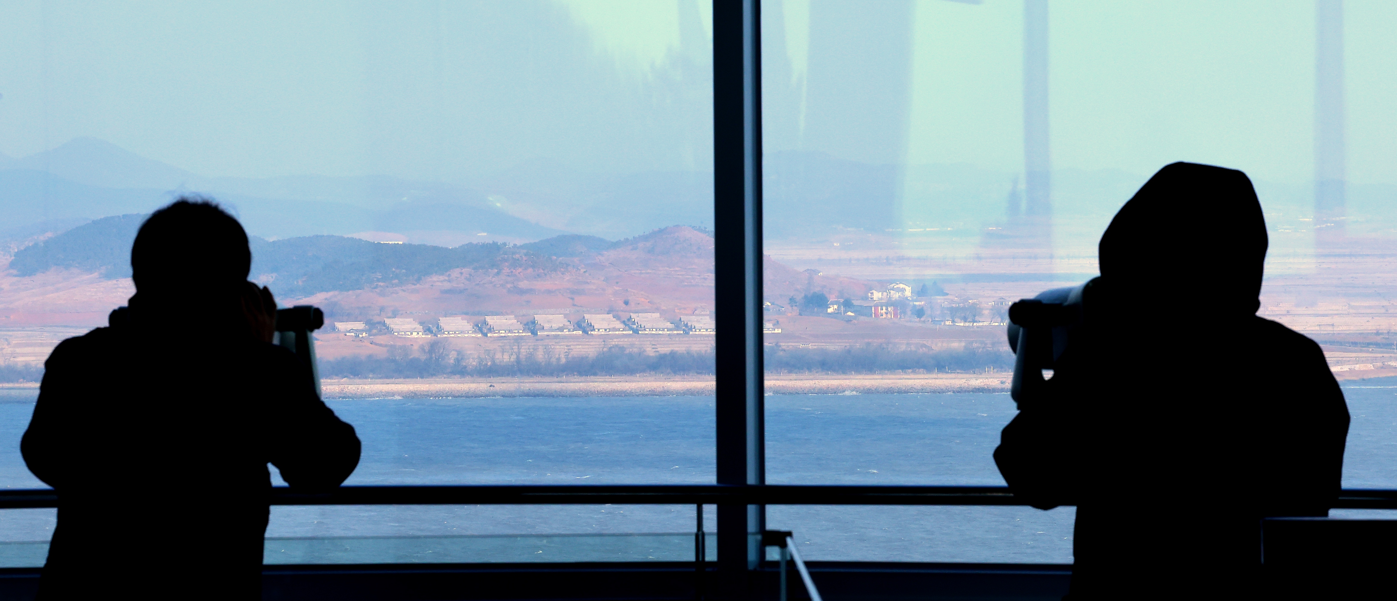 Visitors look at North Korea's border county of Kaepung through tower viewers at South Korea's Ganghwa Peace Observatory in the western county of Ganghwa; 10 January 2026.  EPA/YONHAP SOUTH KOREA OUT