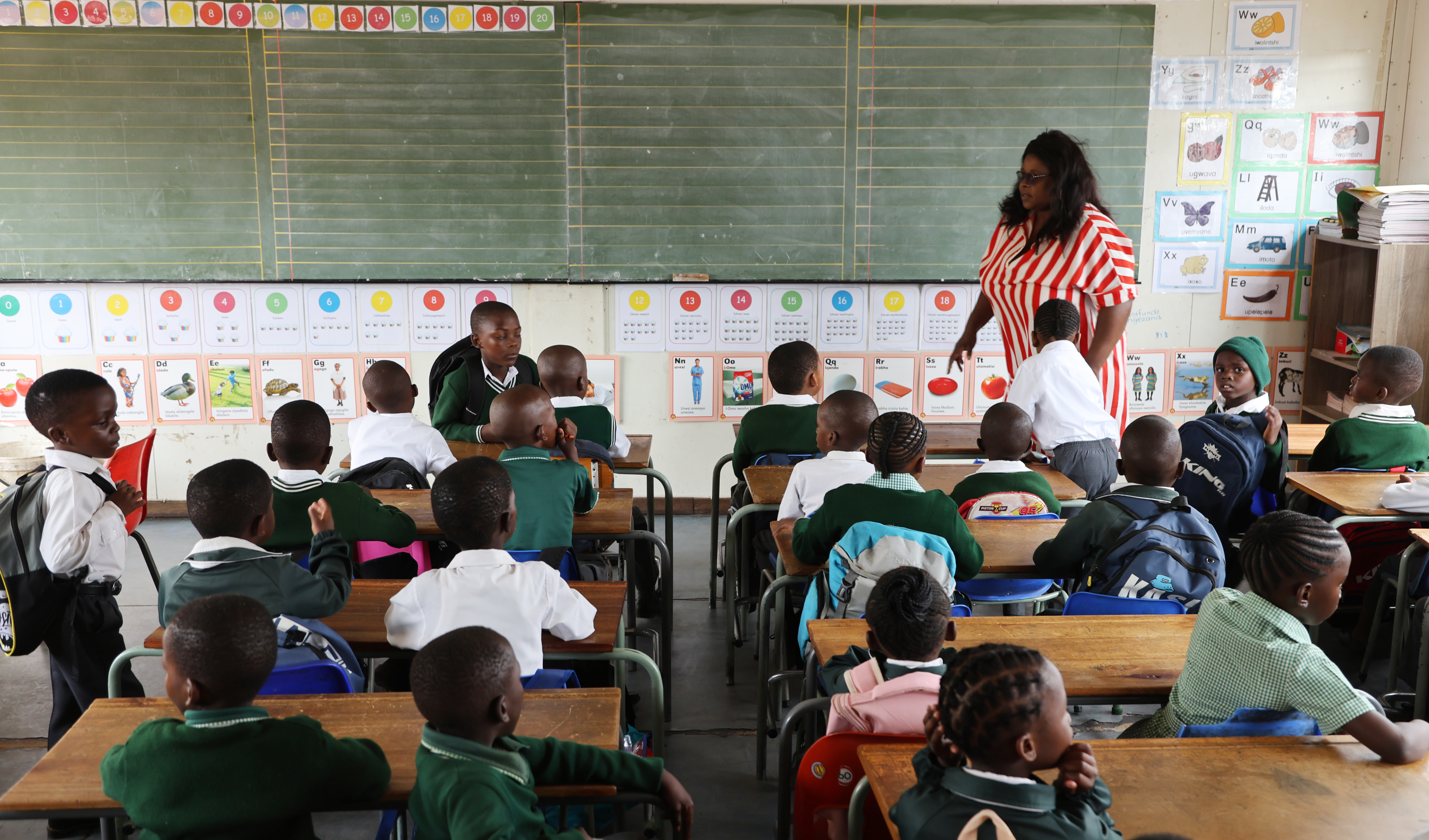 Nompumelelo Zwane, a teacher at Mikateka Primary School in Ivory Park, welcomes Grade 1 learners on the first day of schooling on 14 January 2026. (Photo: Felix Dlangamandla)