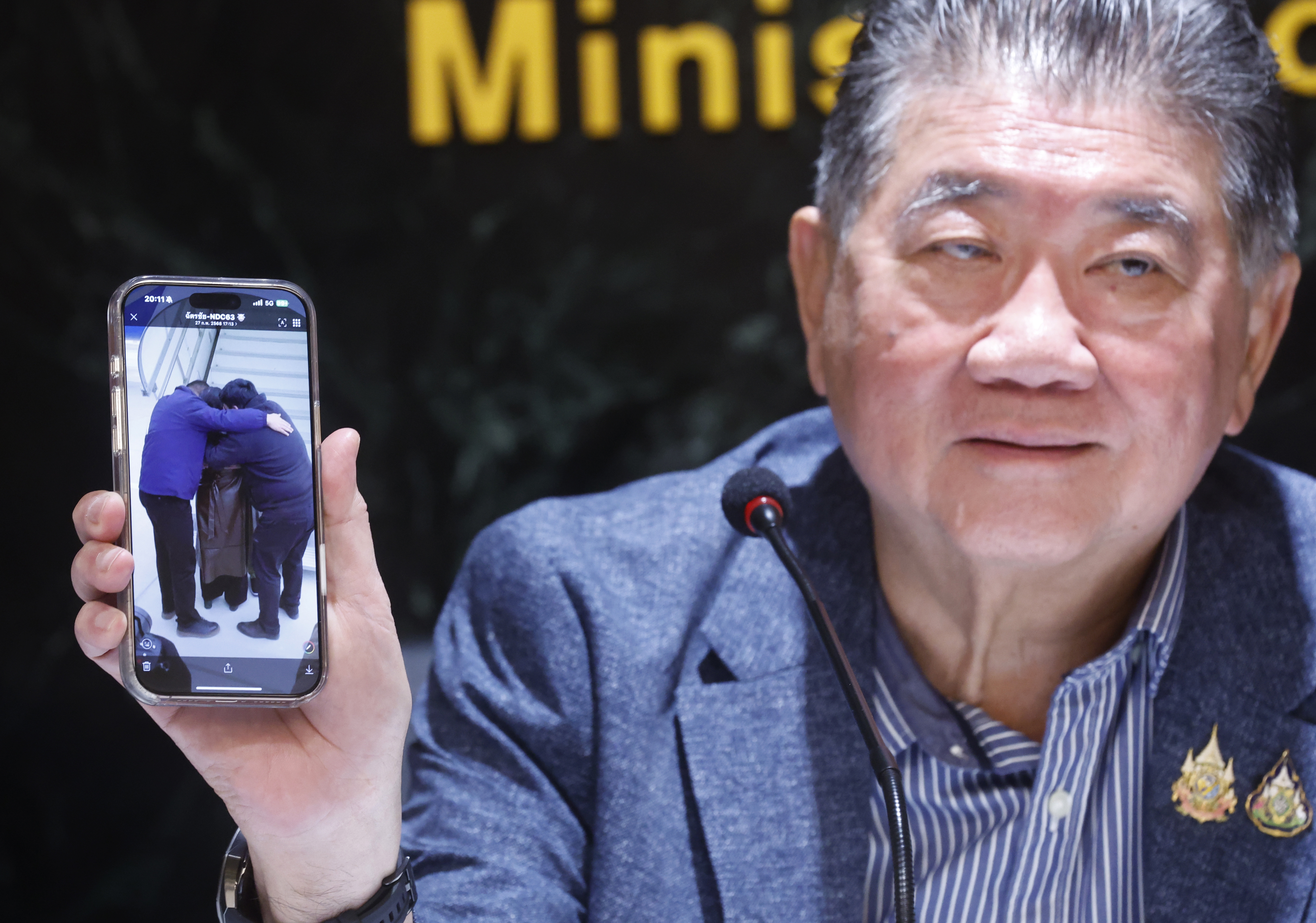 Thai Defense Minister Phumtham Wechayachai shows a picture on his mobile phone of Uyghur refugees upon their arrival at a airport in China,  during a press conference on the deportation of Uyghur refugees detained in Thailand to China, at the Justice Ministry in Bangkok, Thailand, 27 February 2025. Thai authorities stated the deportation of 40 Uyghur refugees detained in Thailand to China, was done under human rights principles. International human rights organizations and activists warn that approximately 48 Uyghur refugees, detained in Thailand since fleeing China in 2014 are at risk of deportation and face potential persecution if returned.  EPA/NARONG SANGNAK
