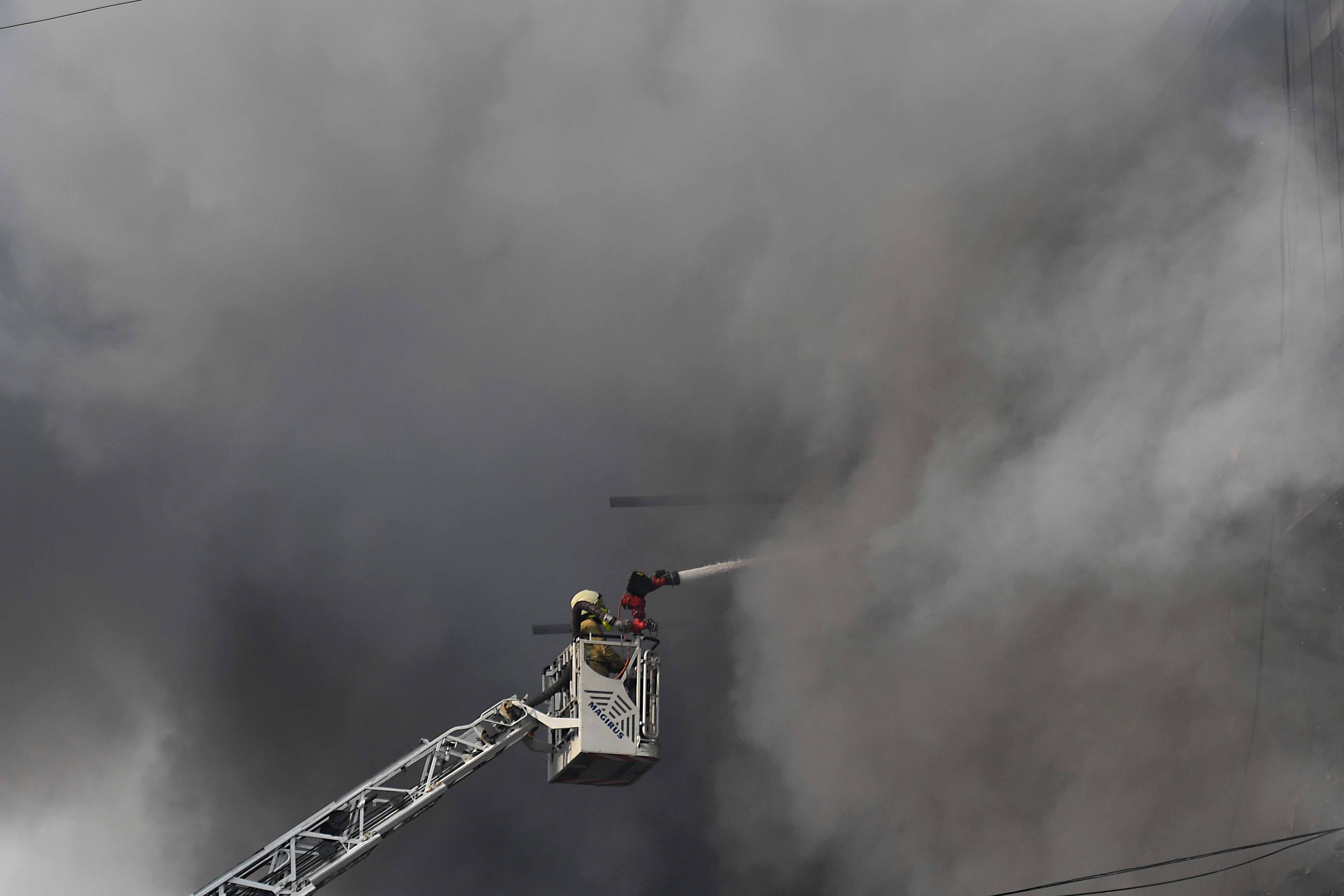 A firefighter battles a massive blaze at Gul Plaza in Karachi, Pakistan, 18 January 2026. At least six people were killed and around 20 injured after a fire swept through Gul Plaza shopping mall, housing about 1,200 shops. Part of the building collapsed, hampering rescue efforts, as firefighters struggled to control the blaze.  EPA/SHAHZAIB AKBER