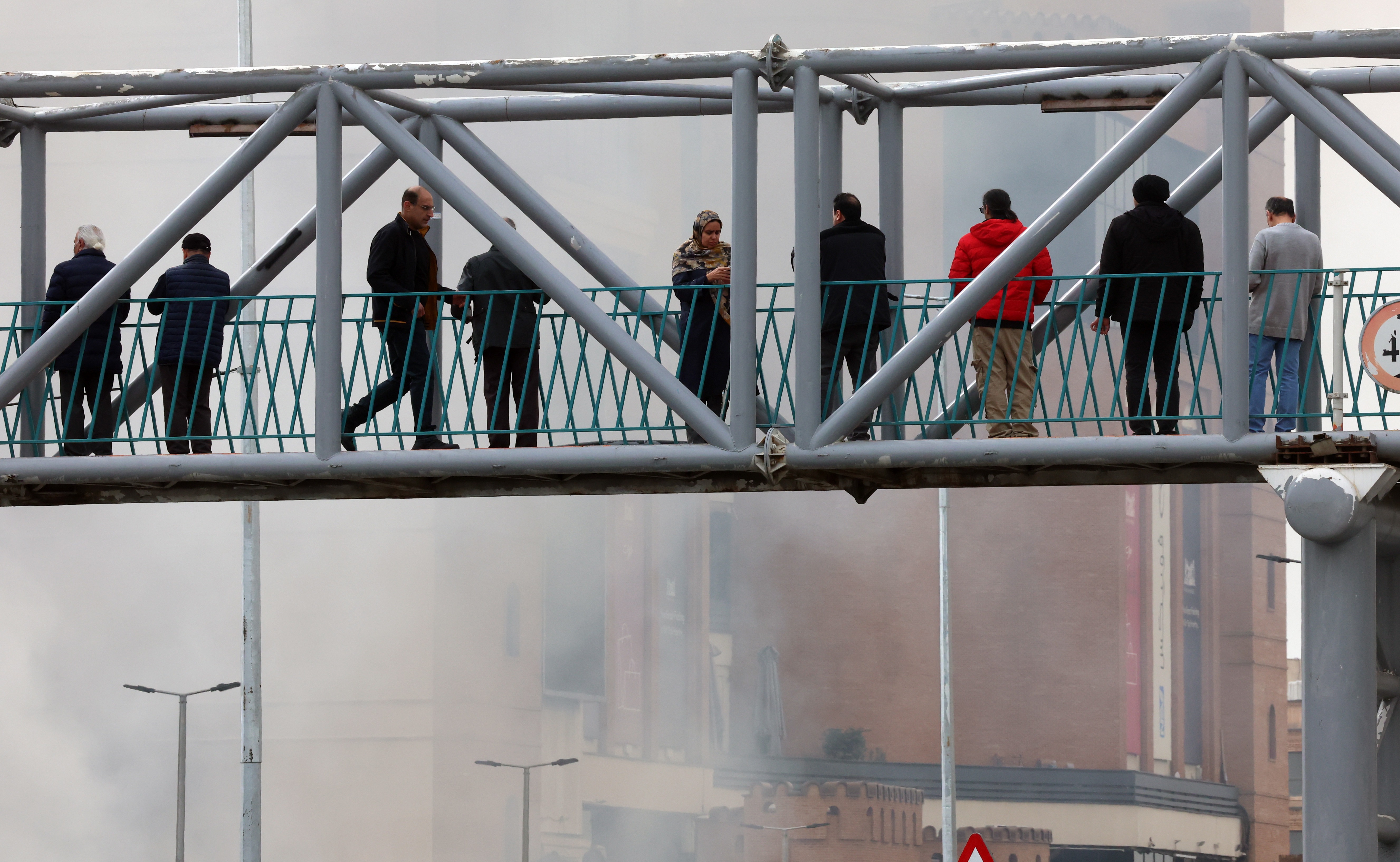 Smoke rises from a fire as people gather around Jannat shopping market in western Tehran, Iran, 03 February 2026. The cause of the fire is unclear.  EPA/ABEDIN TAHERKENAREH