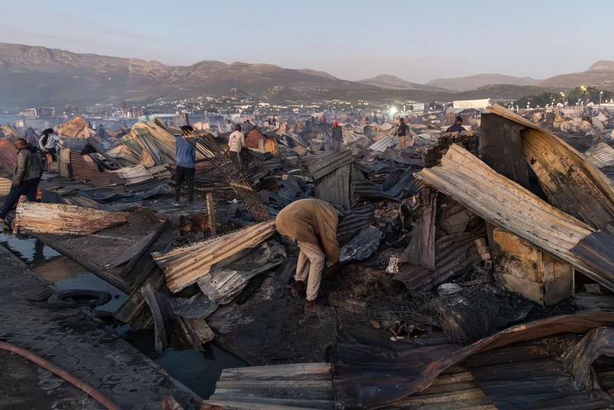 Fire victims sort through their charred belongings after a blaze destroyed more than 100 homes near the wetlands in Masiphumelele on Tuesday afternoon, 20 January 2026. (Photo: Ashraf Hendricks)