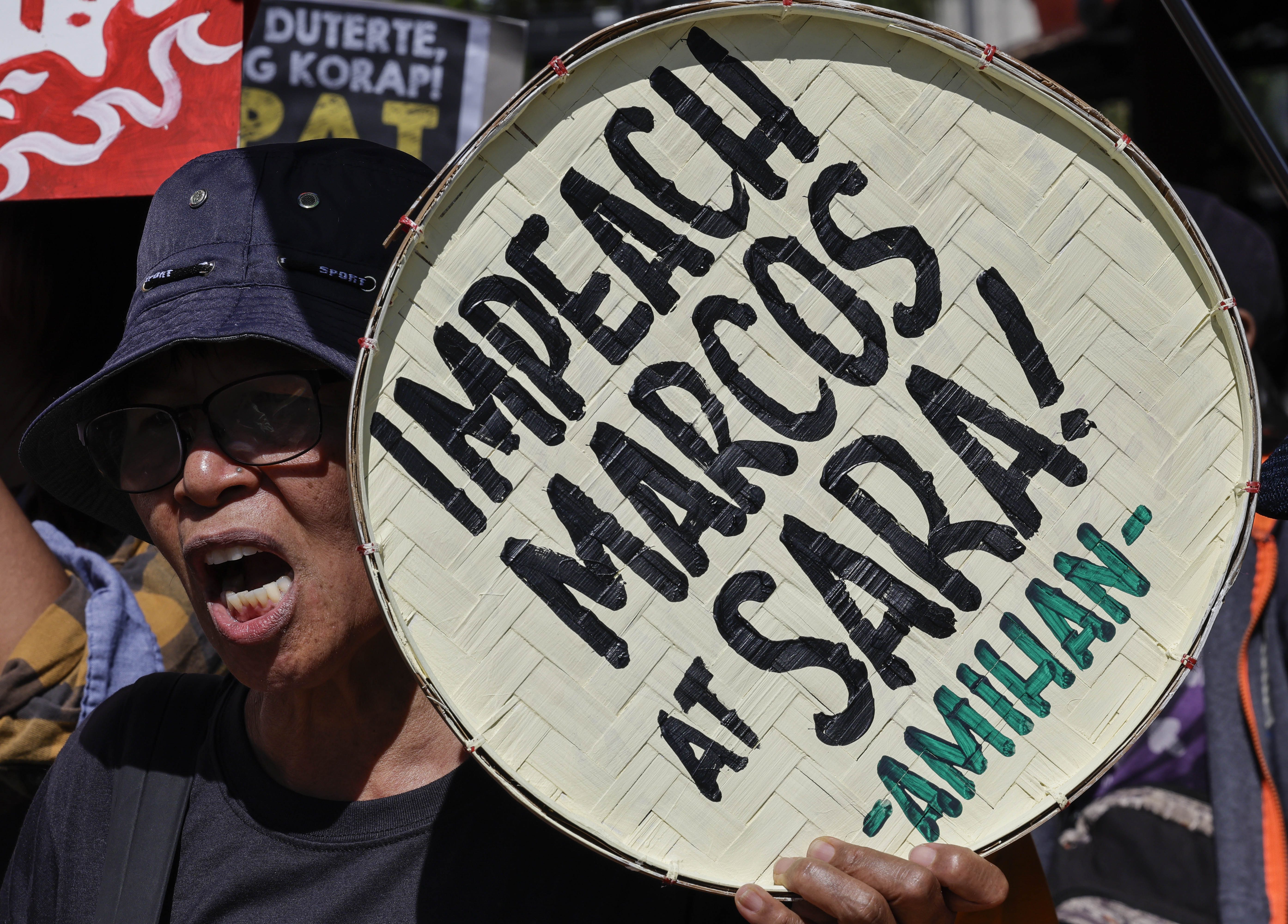 A protester holds a sign calling for the impeachment of Philippine President Ferdinand Marcos Jr., and Vice-President Sara Duterte during a rally outside the House of Representatives (HOR) in Quezon City, Metro Manila, Philippines, 02 February 2026. Two impeachment complaints against Duterte were filed at the HOR on 02 February, as the HOR Justice Committee on the same day deliberates on impeachment complaints filed against Philippine President Ferdinand Marcos Jr.  EPA/ROLEX DELA PENA