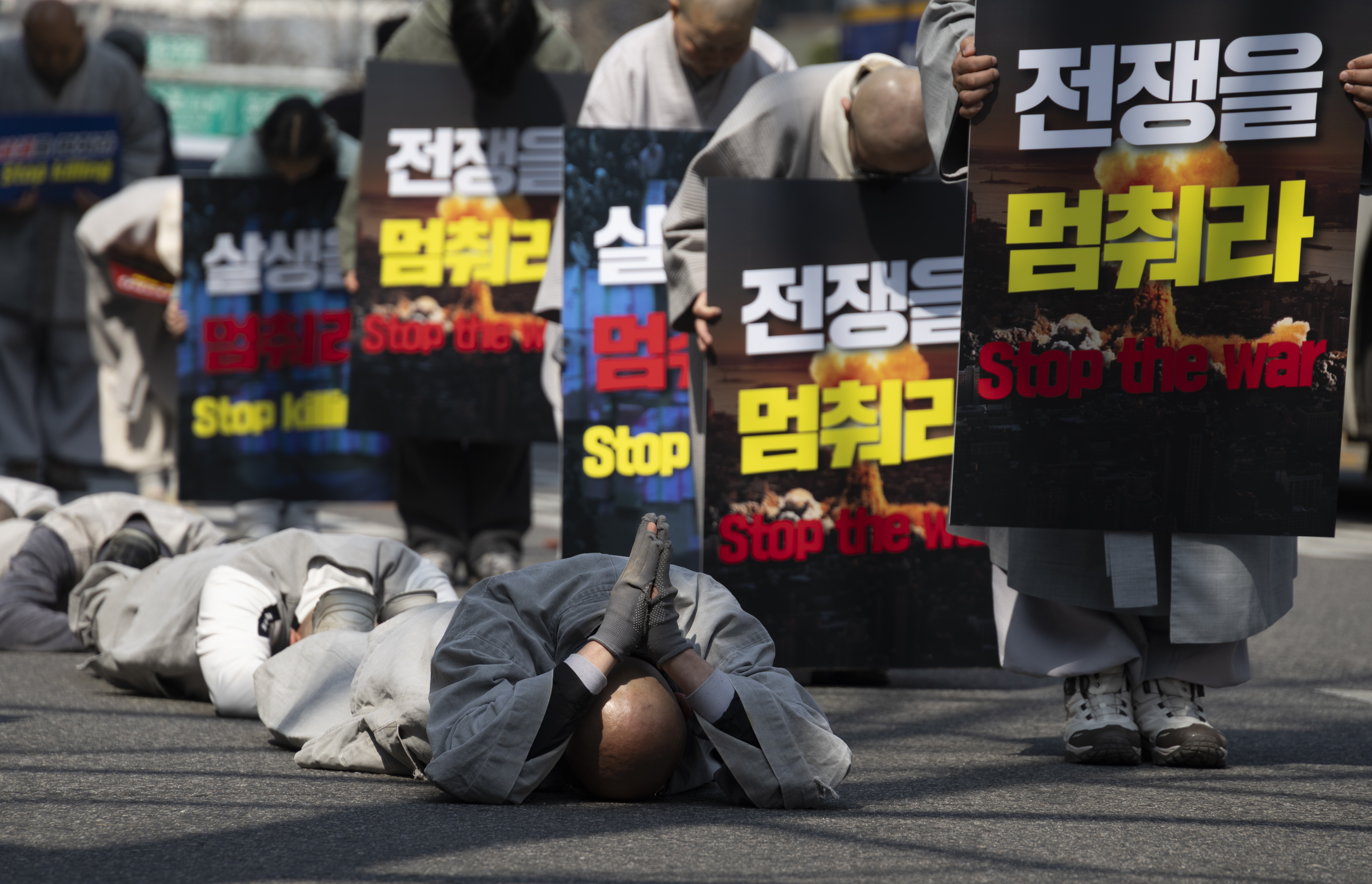 South Korean monks perform the Buddhist praying act of Dharna - walking three steps and making one bow - toward the US Embassy during a protest against US President Trump, in Seoul, South Korea, 17 March 2026. Protesters gathered to oppose Trump?s request for South Korea to send ships to the Strait of Hormuz.  EPA/JEON HEON-KYUN