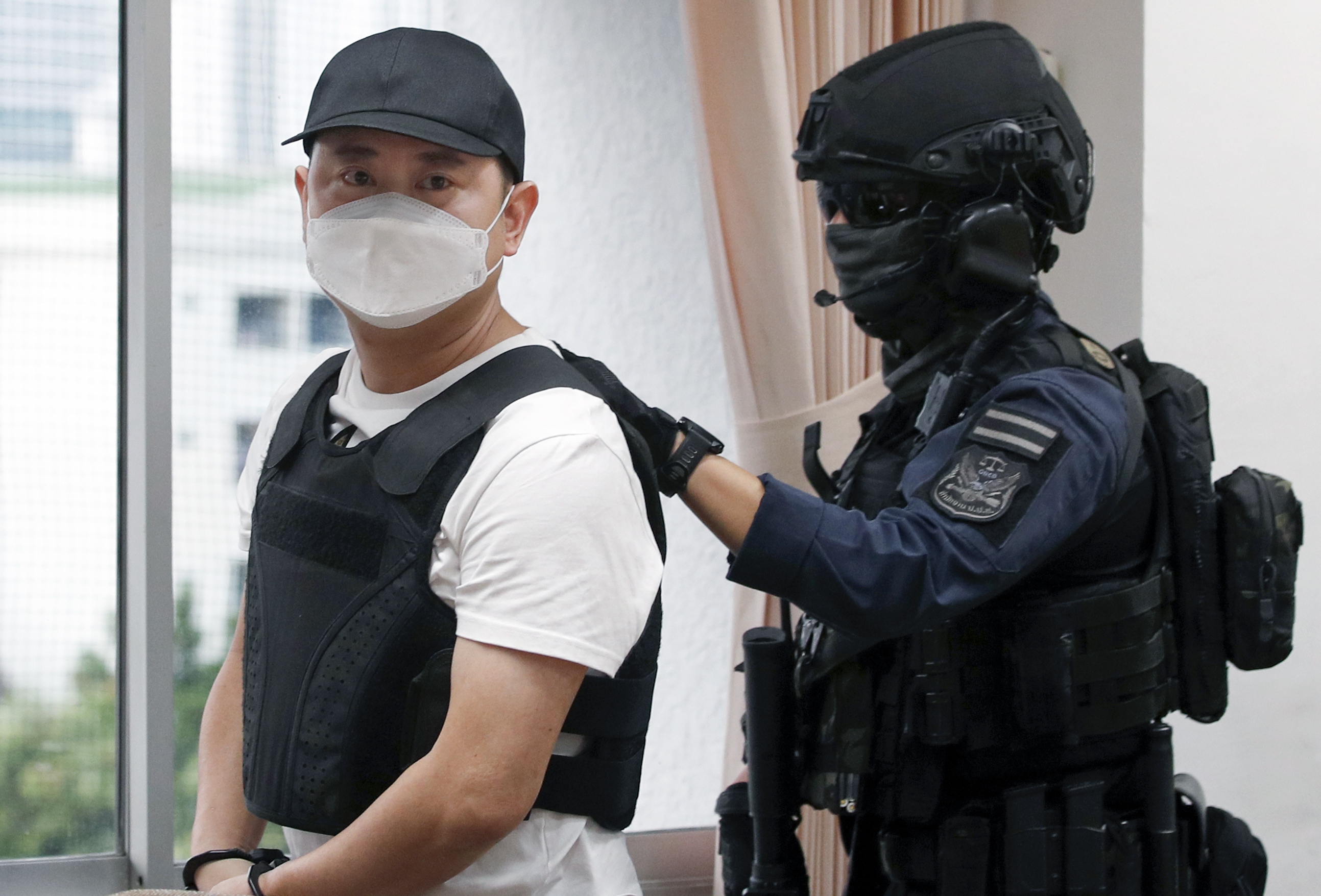 Arrested Malaysian drug lord suspect Ong Gim Wah (L) is escorted by a special force police officer to an investigation at the Office of the Narcotics Control Board in Bangkok, Thailand, 11 January 2024. The Office of the Narcotics Control Board announced the arrest of Malaysian suspected drug kingpin identified as Ong Gim Wah alleged to be an international drug dealer who was captured at a hideout in Laos on 29 December 2023 in a Thai and Laos police joint operation. Ong Gim Wah who had a one million baht bounty (29,000 US dollars or 26,000 euro) was alleged to have a key role in the procurement of drugs and coordinating with drug networks in the Golden Triangle area since 2006 for smuggling drugs to third countries such as Australia, Malaysia and Taiwan and laundering money in Thailand, according to the Secretary-General of the Office of the Narcotics Control Board (ONCB) Police Lieutenant General Phanurat Lukboon.  EPA/RUNGROJ YONGRIT