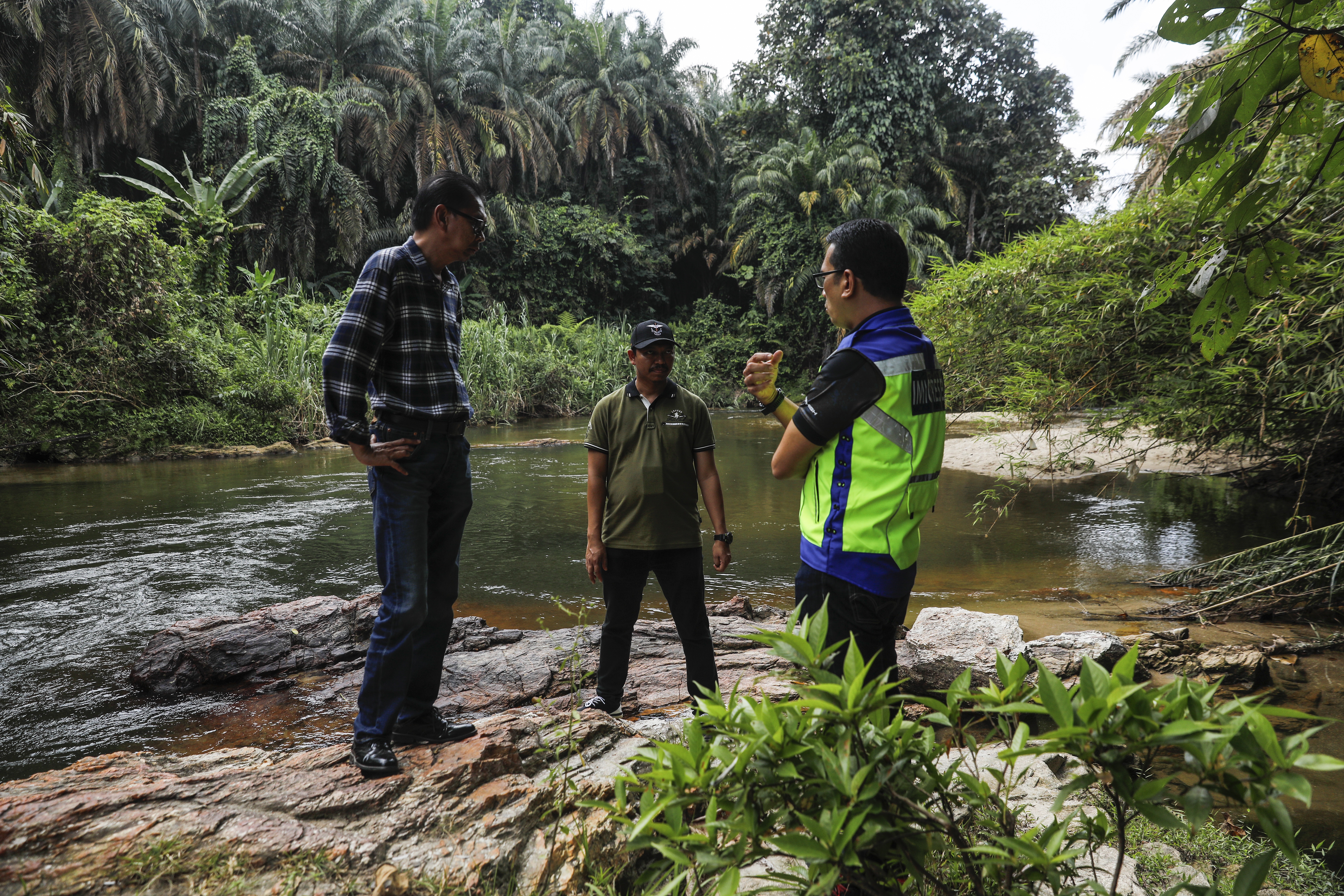 Malaysia Immigration Department officers inspect the river near the detention centre at Bidor, state of Perak, Malaysia, 02 February 2024. About 275 officers from various agencies, including the immigration department, police, the General Operations Force (GOF), and the Malaysian Volunteers Department (Rela) were deployed shortly after more than 100 Rohingya refugees escaped the detention center.  EPA/FAZRY ISMAIL