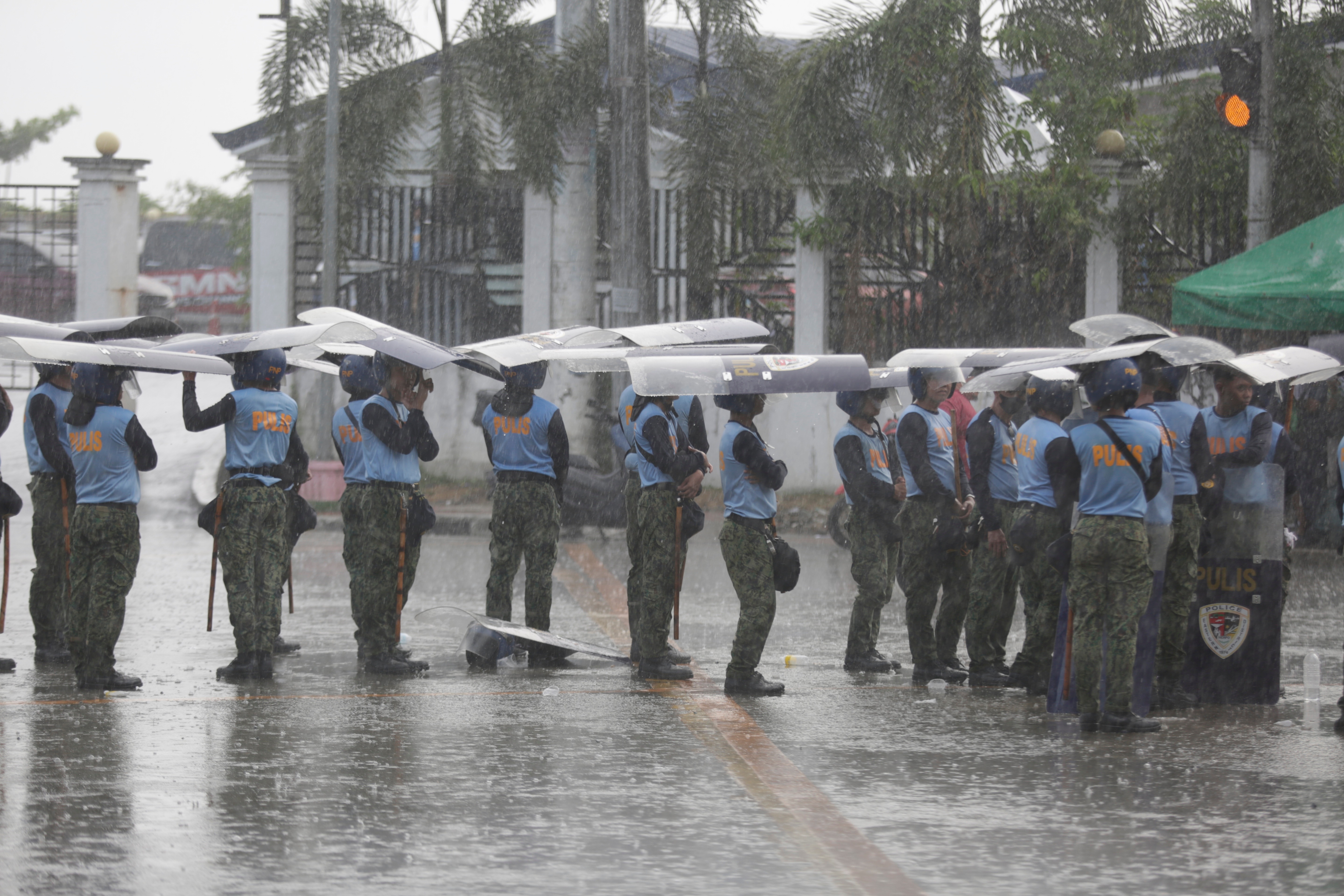 Anti-riot police use their shields to shelter from rain as they stand guard outside the Philippine Senate as jurors convene as an impeachment court for the trial of Vice President Sara Duterte at the Philippine Senate in Pasay City, Metro Manila, Philippines, 18 May 2026. The Senate will deliberate charges of corruption against Duterte, as the legislative body also deals with the continued absence of Senator Ronald dela Rosa, who is the subject of an International Criminal Court (ICC) arrest warrant. EPA/FRANCIS R. MALASIG

