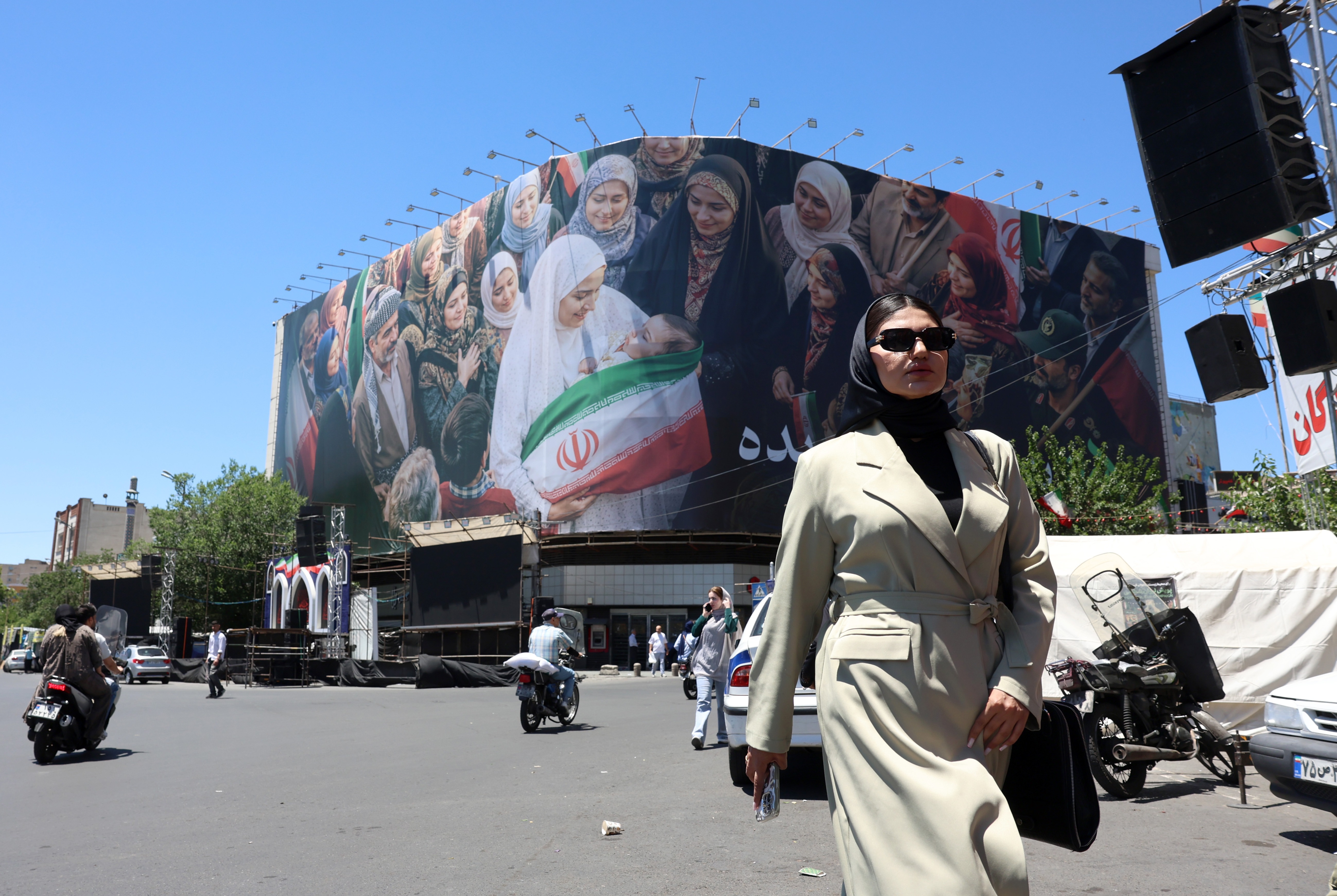 A woman walks next to a huge billboard in a street in Tehran, Iran, 25 May 2026. The US and Iran voiced optimism regarding a potential peace agreement and the reopening of the Strait of Hormuz, though both sides emphasized that no such deal has been reached yet. EPA/ABEDIN TAHERKENAREH
