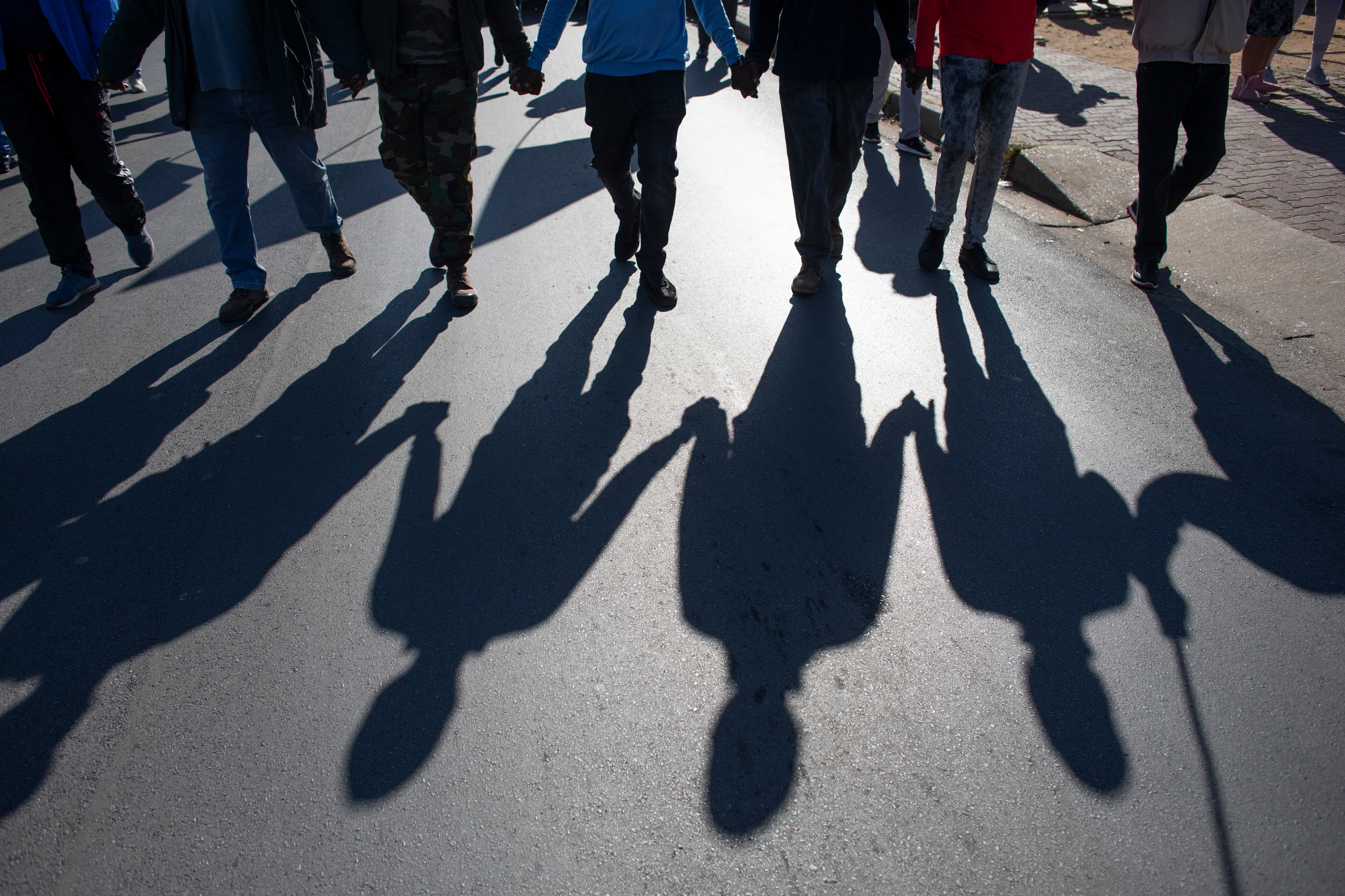 Residents walk hand in hand during a march through the streets of Soweto by South African's wanting the removal of foreign residents from the area as well as the eviction of people from various local buildings, Johannesburg, South Africa, 16 June 2021. 'Illigal residents'; or foreigners where removed, along with some South Africa students, from a nearby post office that had been taken over as an illegal commune. The country has been blighted by xenophobia attacks on foreigners over the past years and most recently people where evicted from their shops in Soweto overnight. EPA/Kim Ludbrook