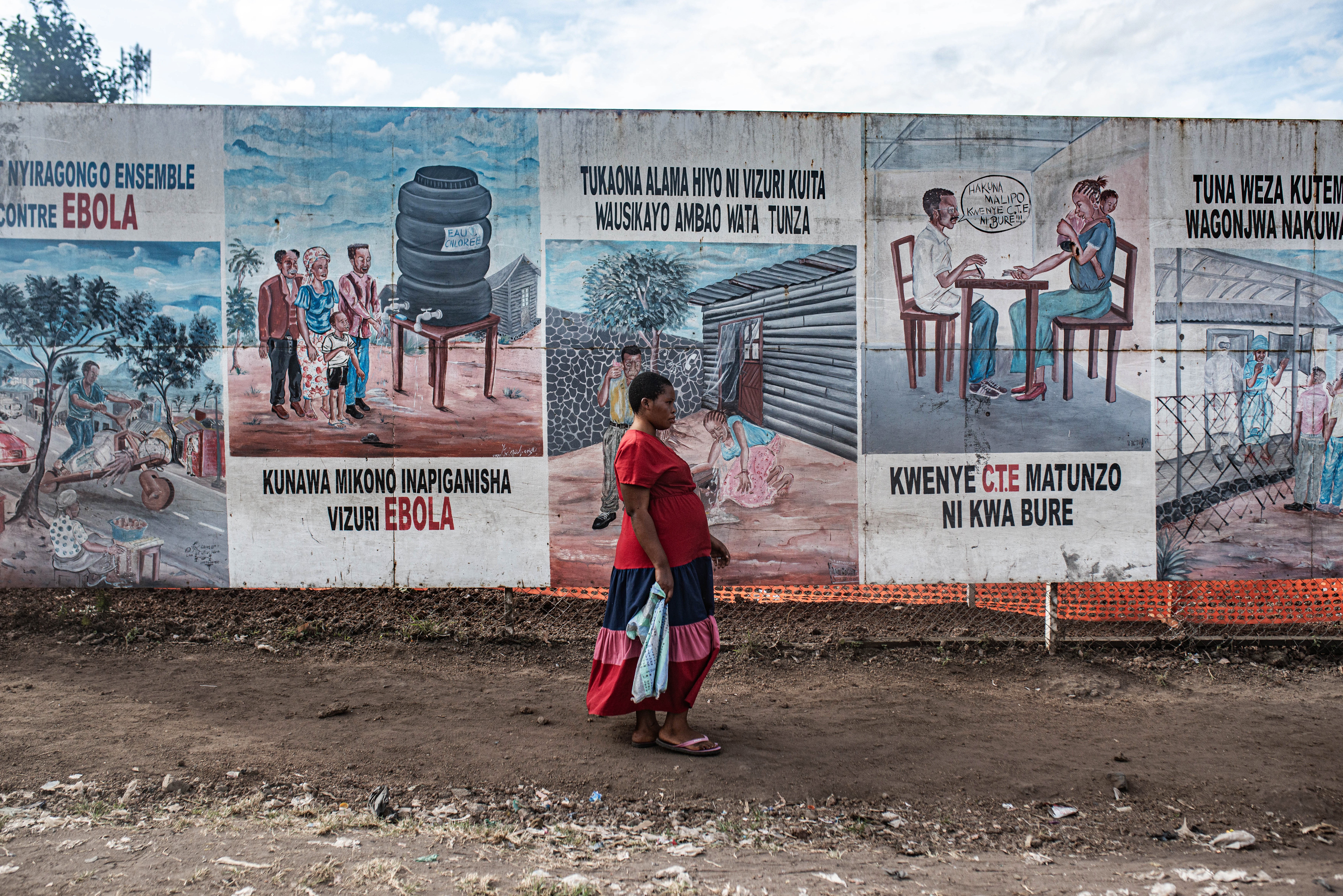 A woman walks by posters warning about Ebola near an Ebola treatment center on June 2, 2026 in Monigi, Democratic Republic of Congo.  (Photo by Daniel Buuma/Getty Images)