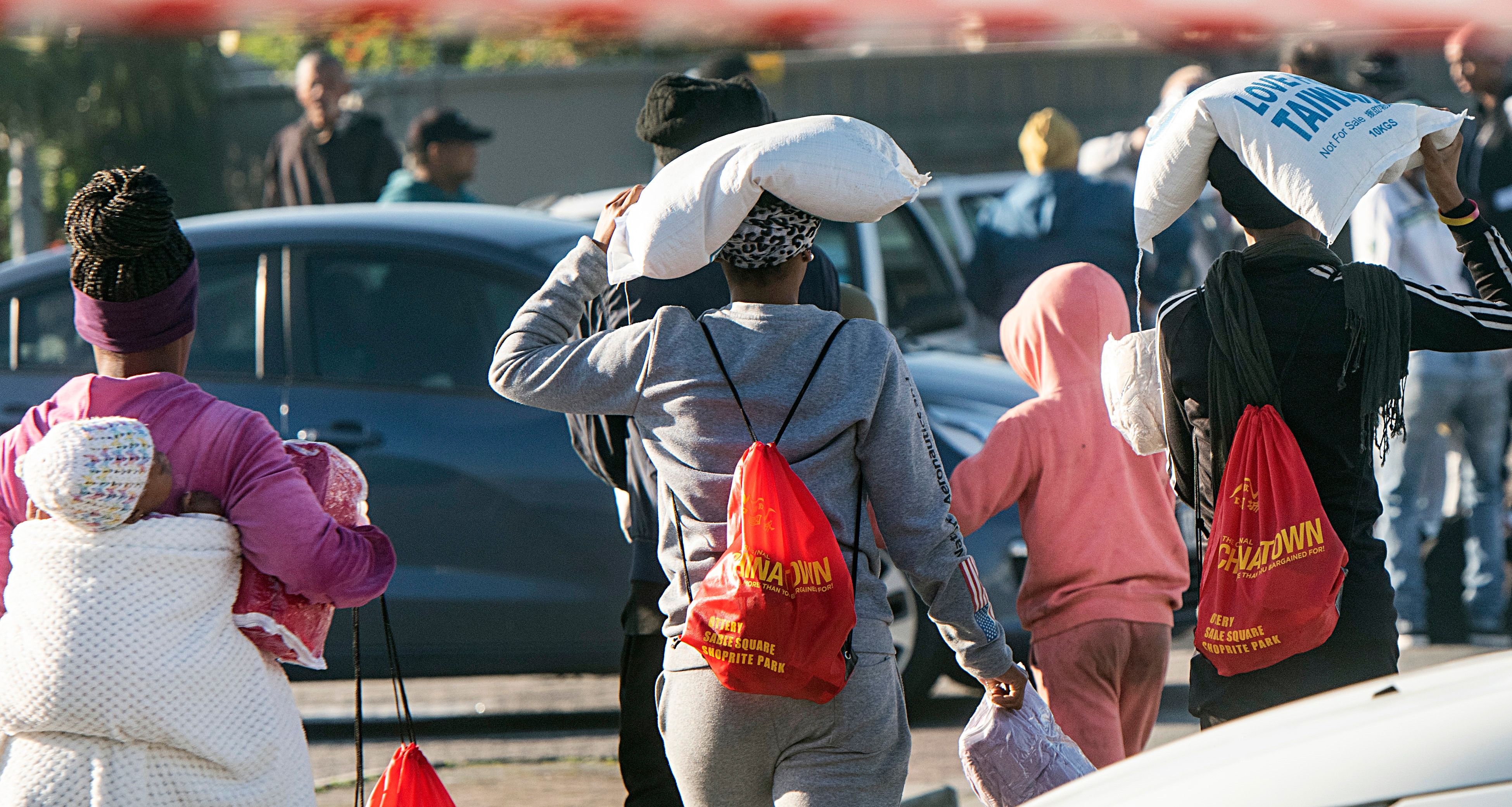 South Africans carry sacks of basic foodstuffs as the country’s hunger crisis worsens. (Photo: Brenton Geach / Gallo Image)