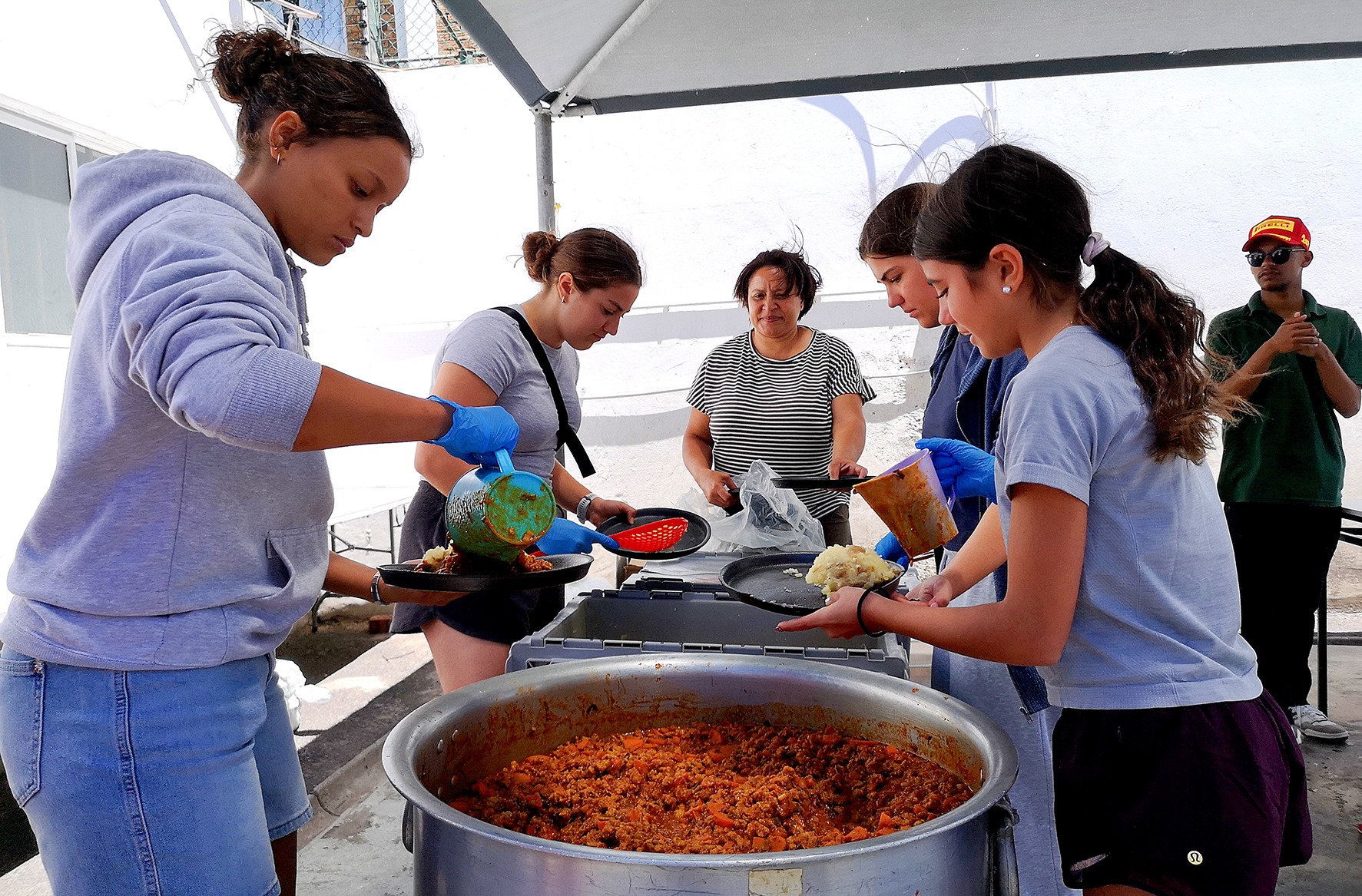 Volunteers serve meals to unhoused persons in Cape Town’s CBD as part of Ladles of Love and the Hope Exchange’s festive season soup kitchen on 24 December. (Photo: Tamsin Metelerkamp)