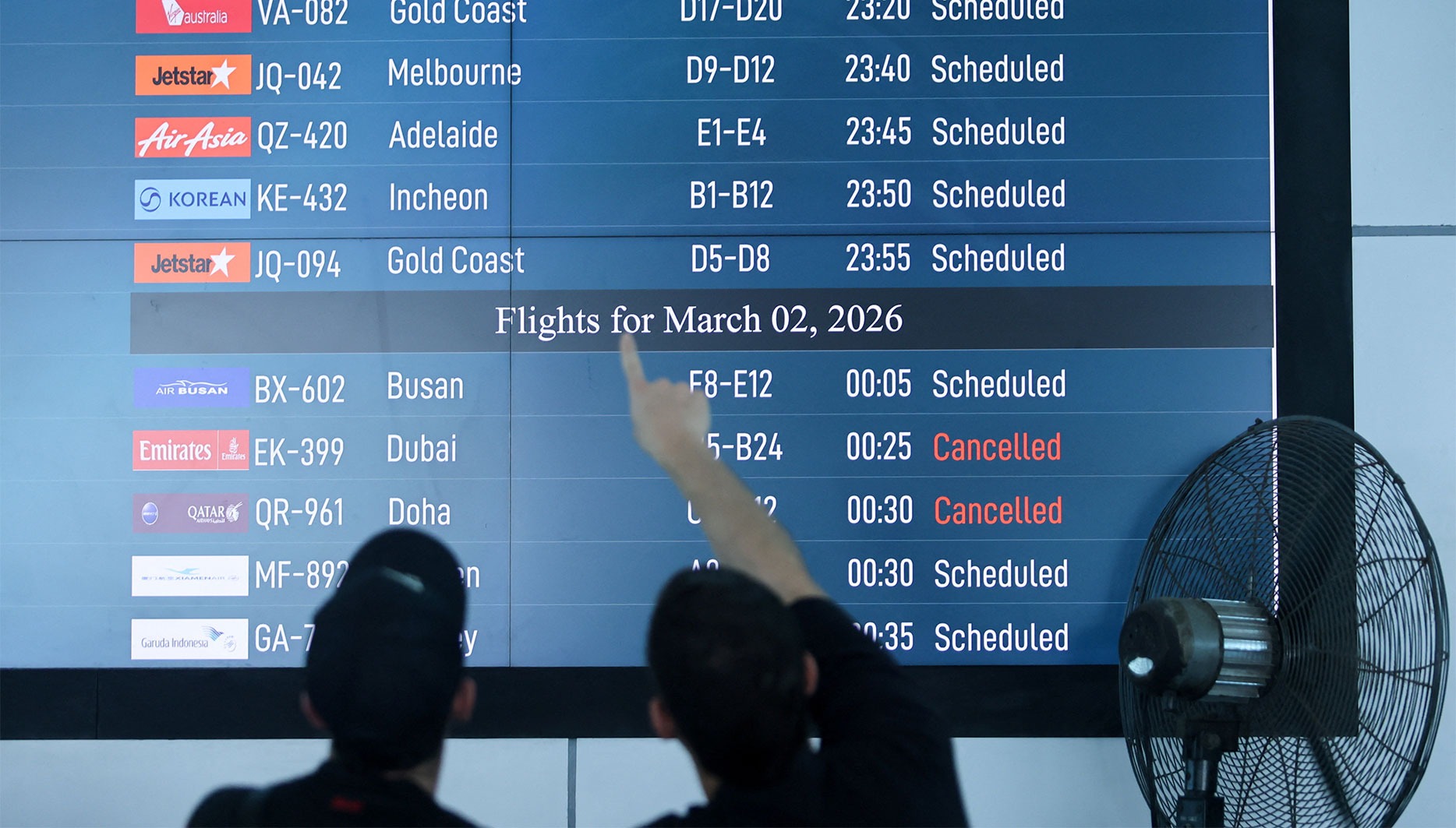 Passengers look at the departure board at I Gusti Ngurah Rai International Airport in Bali, Indonesia, on 1 March after some flights to Dubai and Doha were cancelled following the US and Israeli strikes on Iran. (Photo Johannes Christo / Reuters)