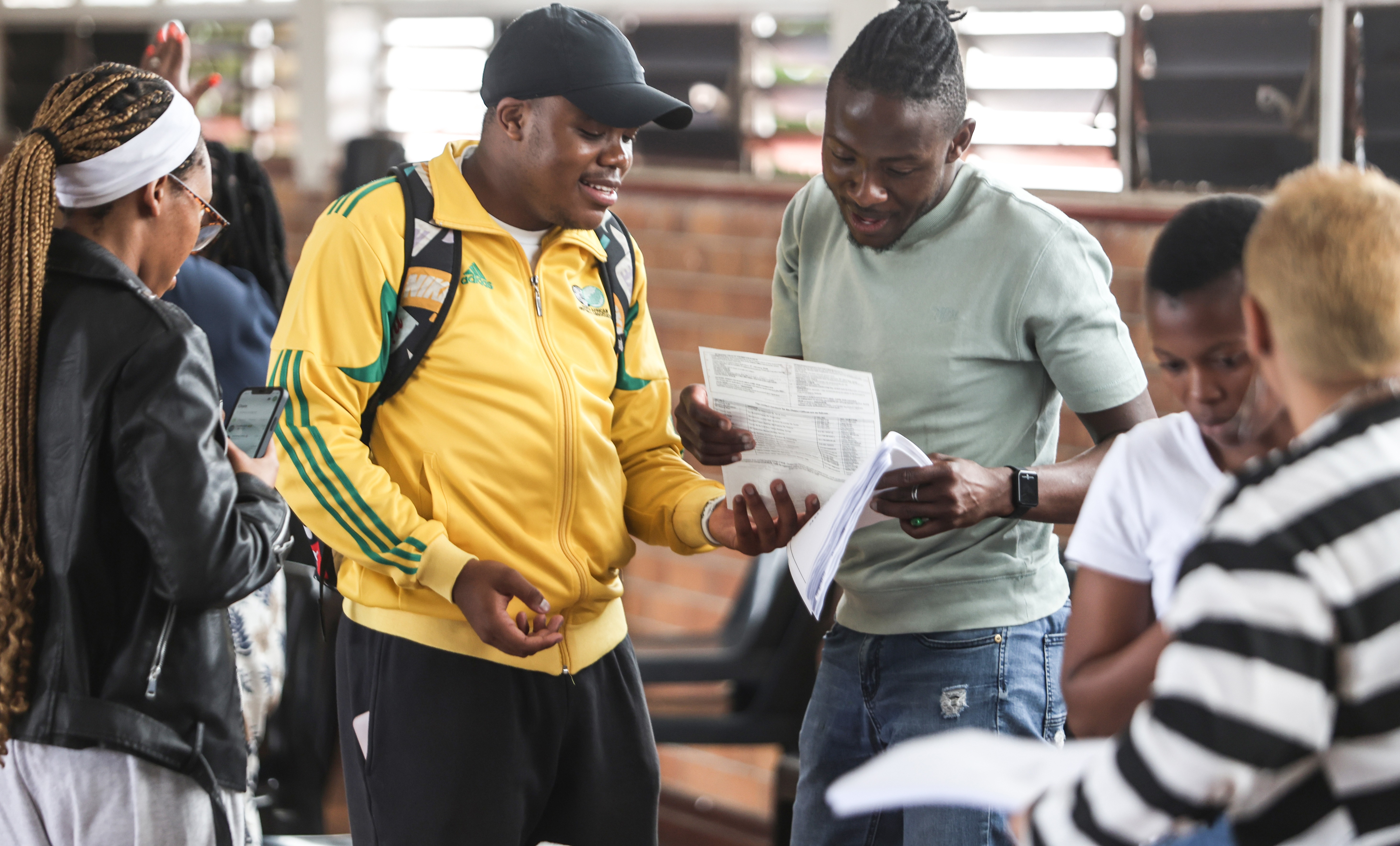 Junior Malaka, a teacher, chats with learners Tshepiso Mofokeng and Mbali Ngubane after they attained top matric results at Florida High School. (Photo: Felix Dlangamandla)