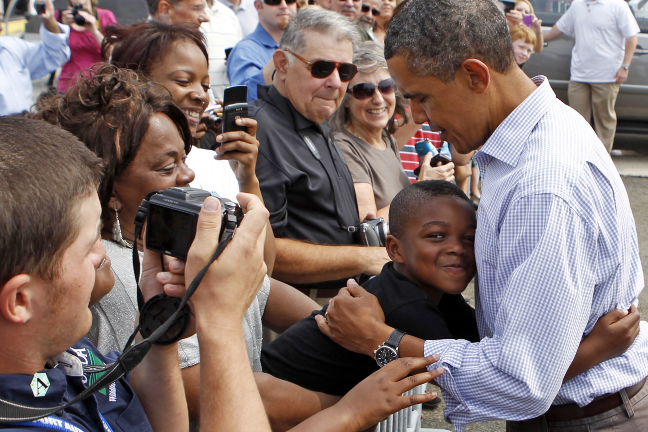 U.S. President Barack Obama gets a hug from a boy upon his arrival in Newark, New Jersey