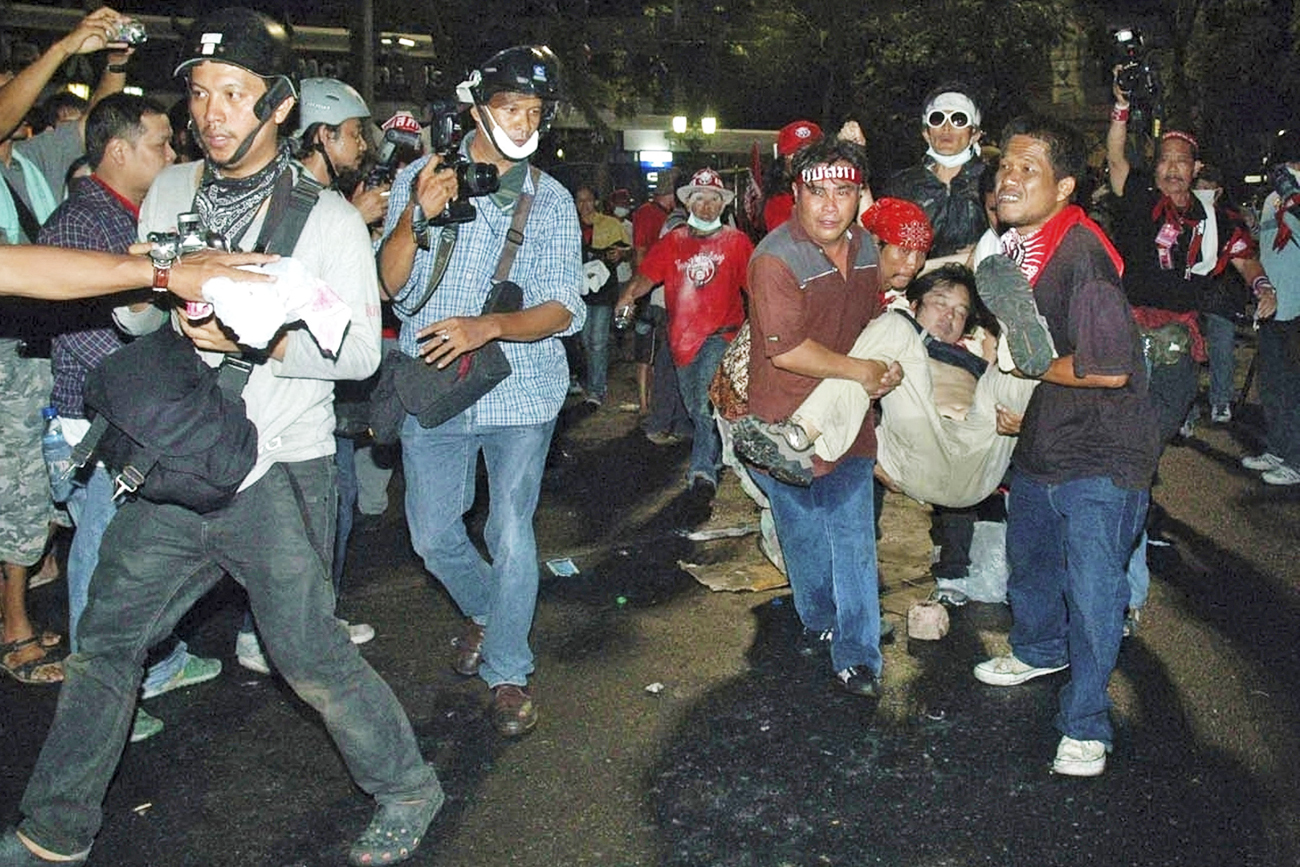 Anti-government protesters carry Reuters television cameraman Hiro Muramoto after he was shot during clashes in central Bangkok