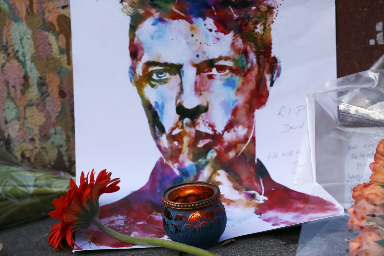 Tributes are seen next to a mural of David Bowie in Brixton, south London