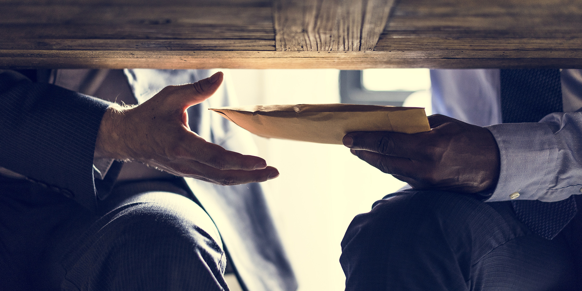 Business people sending documents under the table