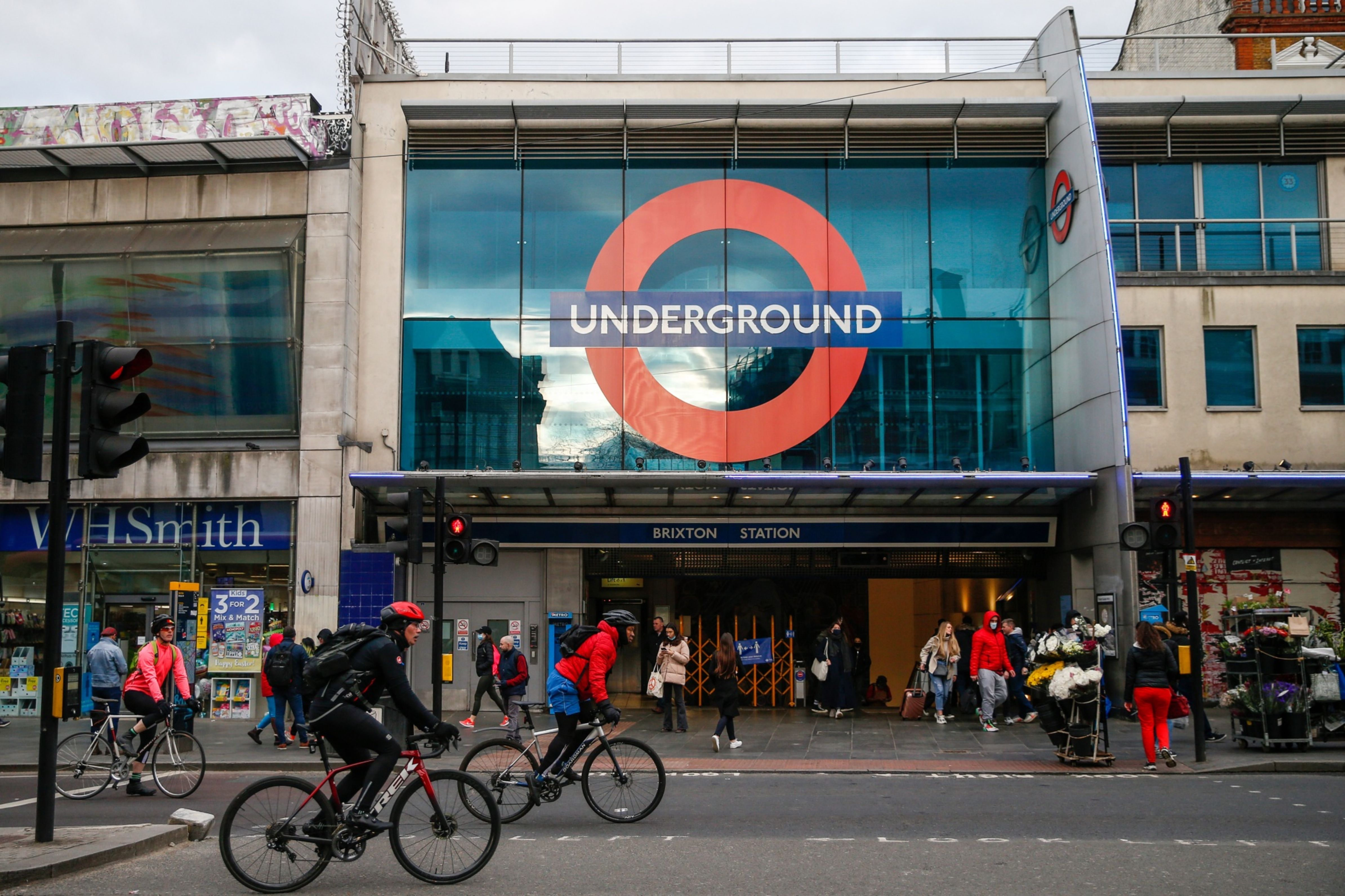 Cyclists ride pass Brixton London Underground Station in London, U.K., on Wednesday, April 7, 2021. British voters' attitudes are hardening against the European Union in the wake of the clashes between London and Brussels over coronavirus vaccines that have marked the 100 days since the U.K. completed its divorce from the bloc. Photographer: Hollie Adams/Bloomberg
