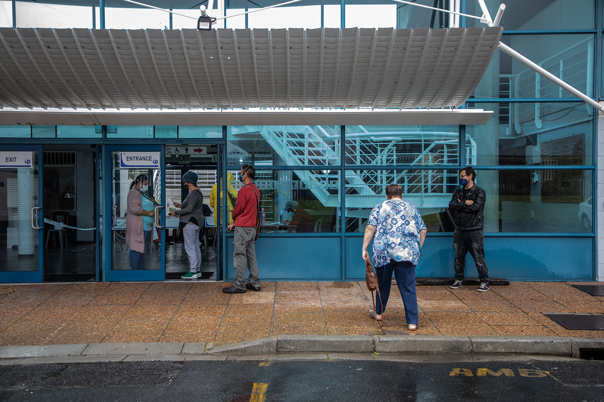 Voters jump over puddles while ducking the rain to get to the voting station