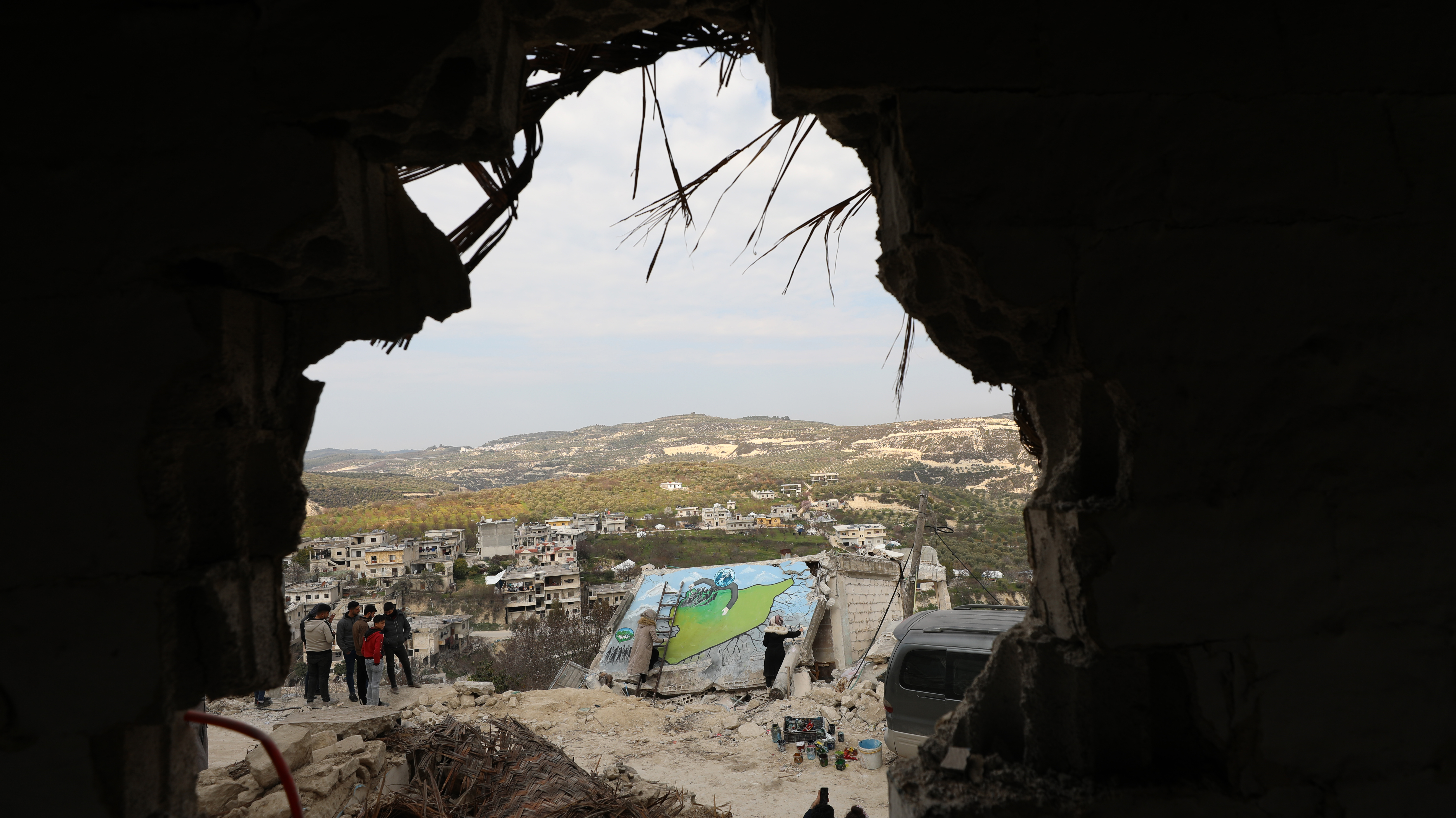 Syrian artists paint walls of destroyed buildings in the earthquake area in Northern Syria