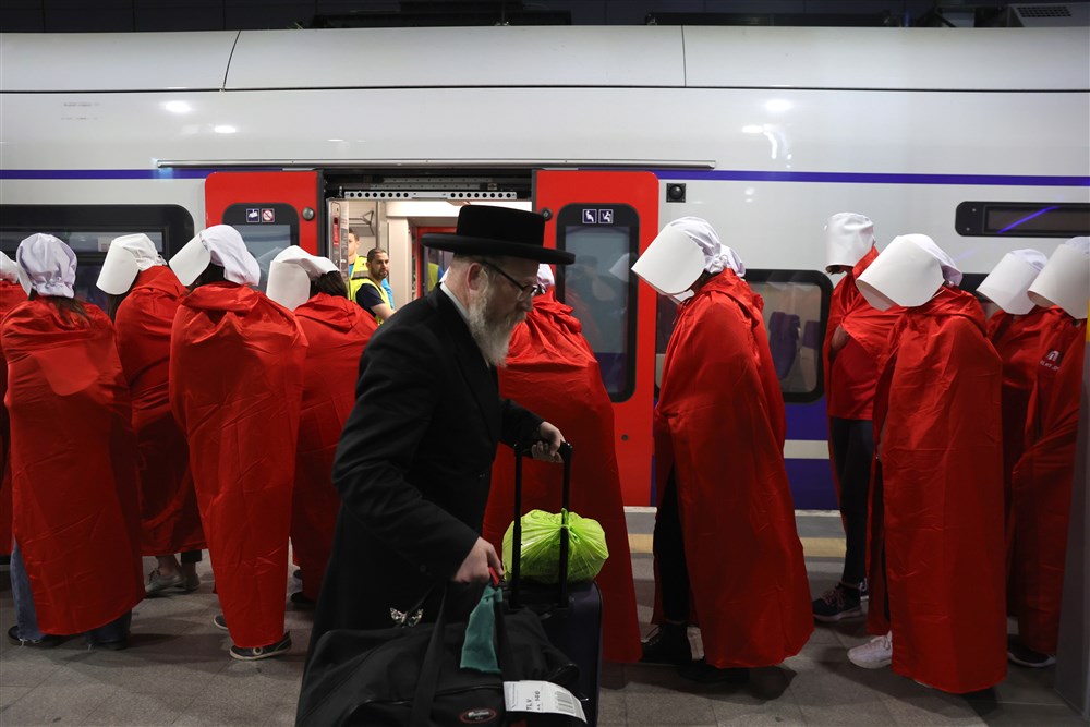 In images: Women in 'Handmaid's Tale' costume ride a train during an anti-government protest in Jerusalem