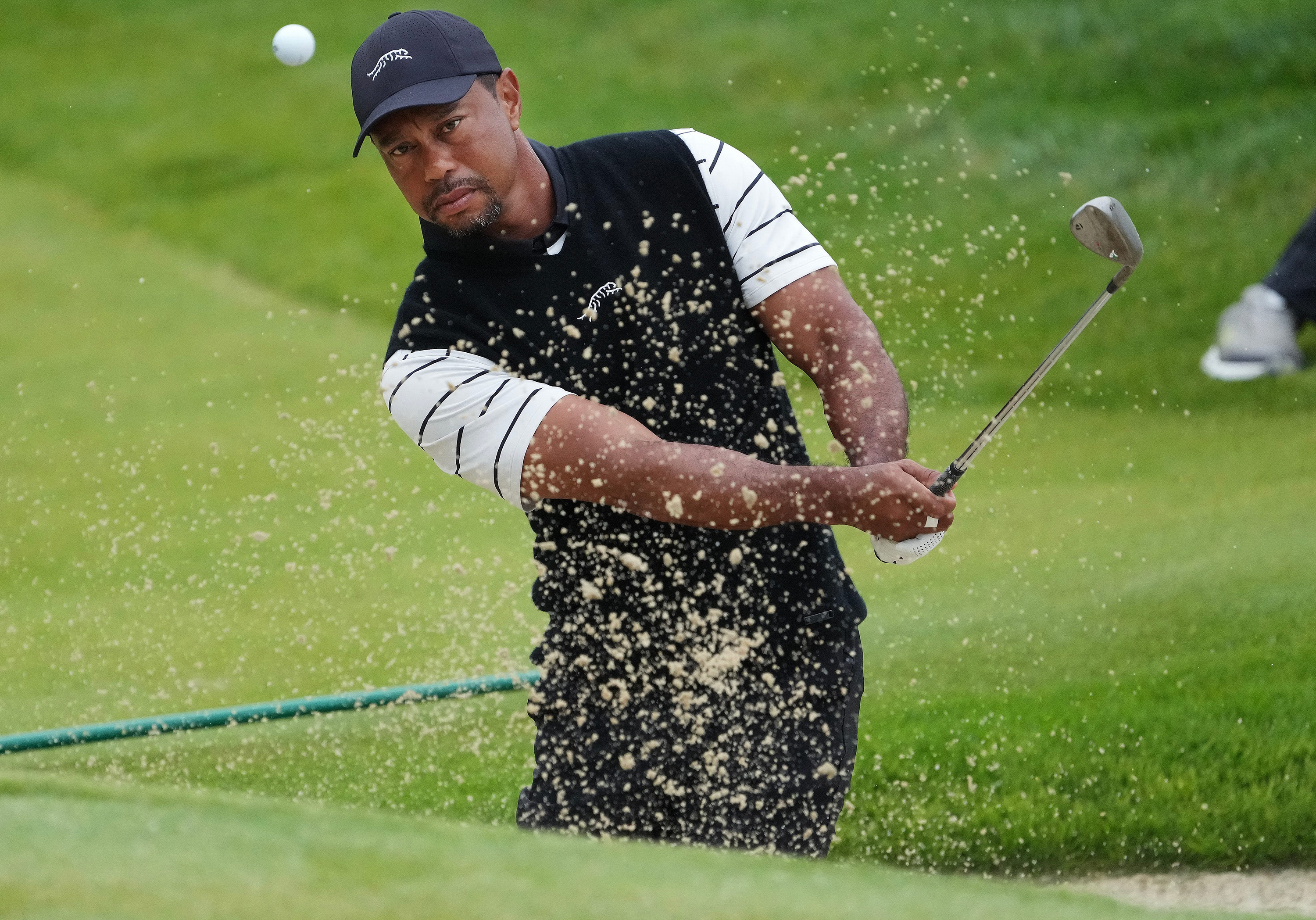 May 14, 2024; Louisville, Kentucky, USA; Tiger Woods hits a bunker shot on the 3rd green during a practice round for the PGA Championship golf tournament at Valhalla Golf Club. Mandatory Credit: Sam Upshaw Jr.-USA TODAY Sports