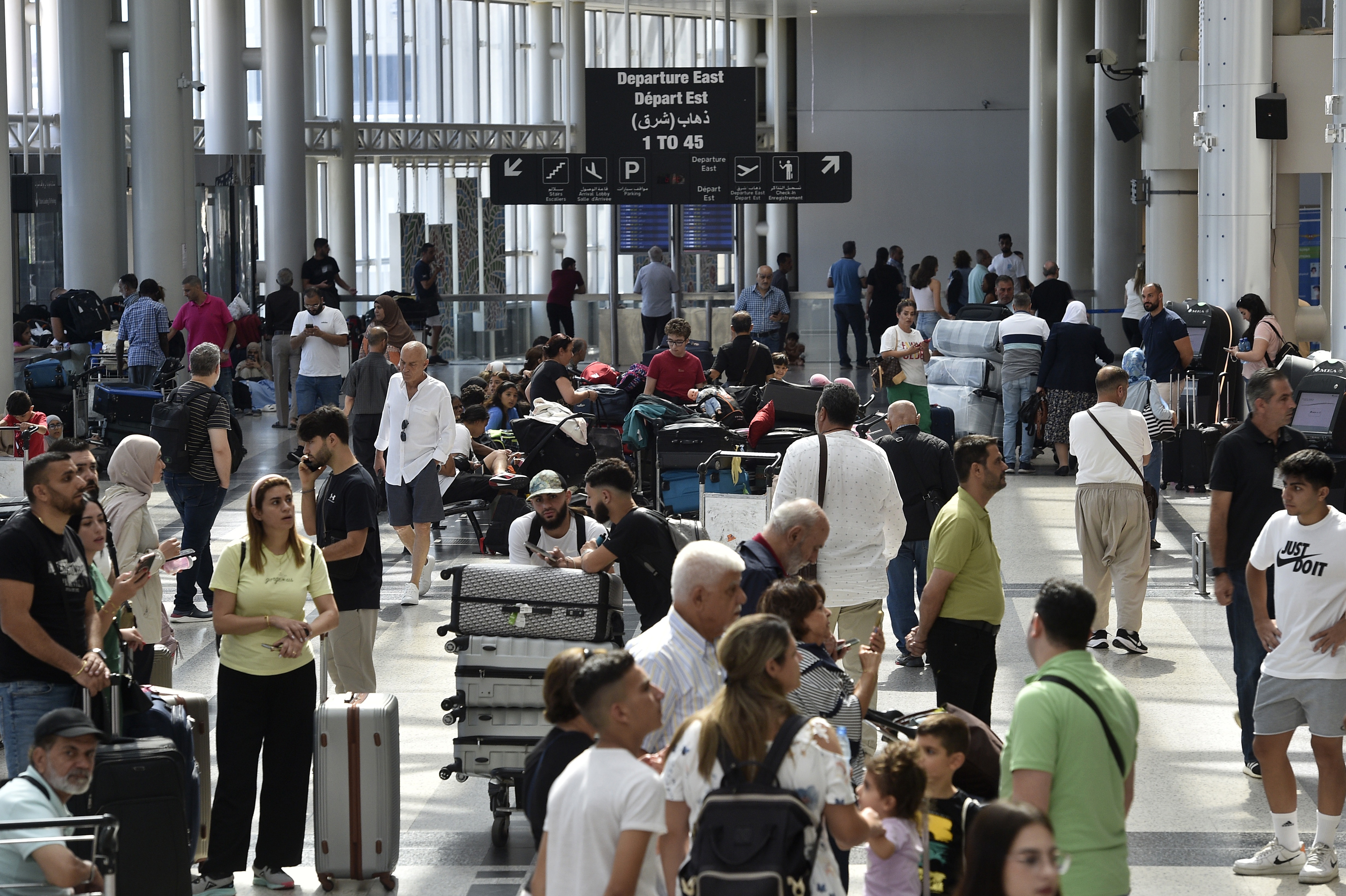 Passengers wait in Beirut's airport after flights were delayed or canceled
