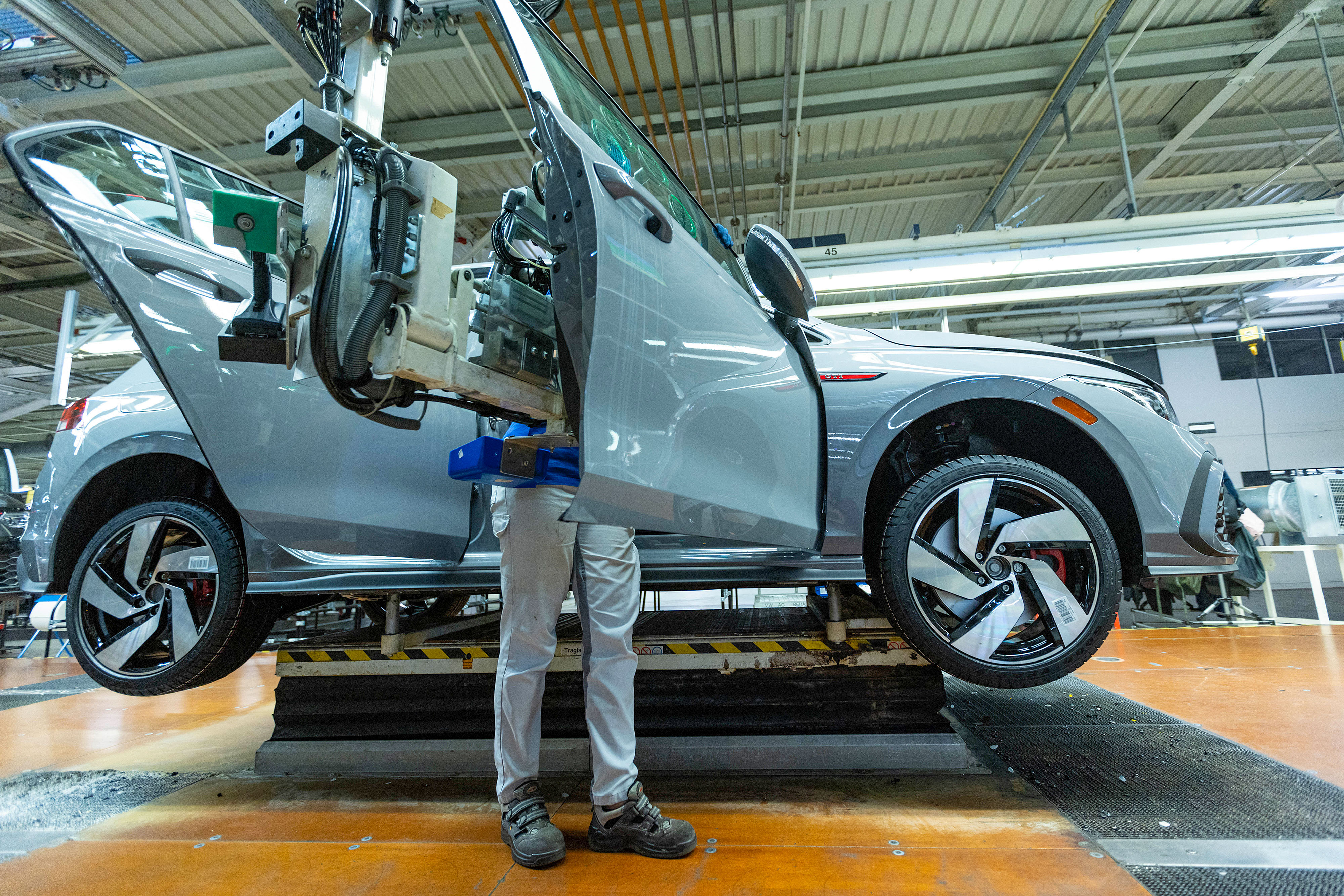 A worker fits a door to a VW Golf on the assembly line at the Volkswagen factory in Wolfsburg.
