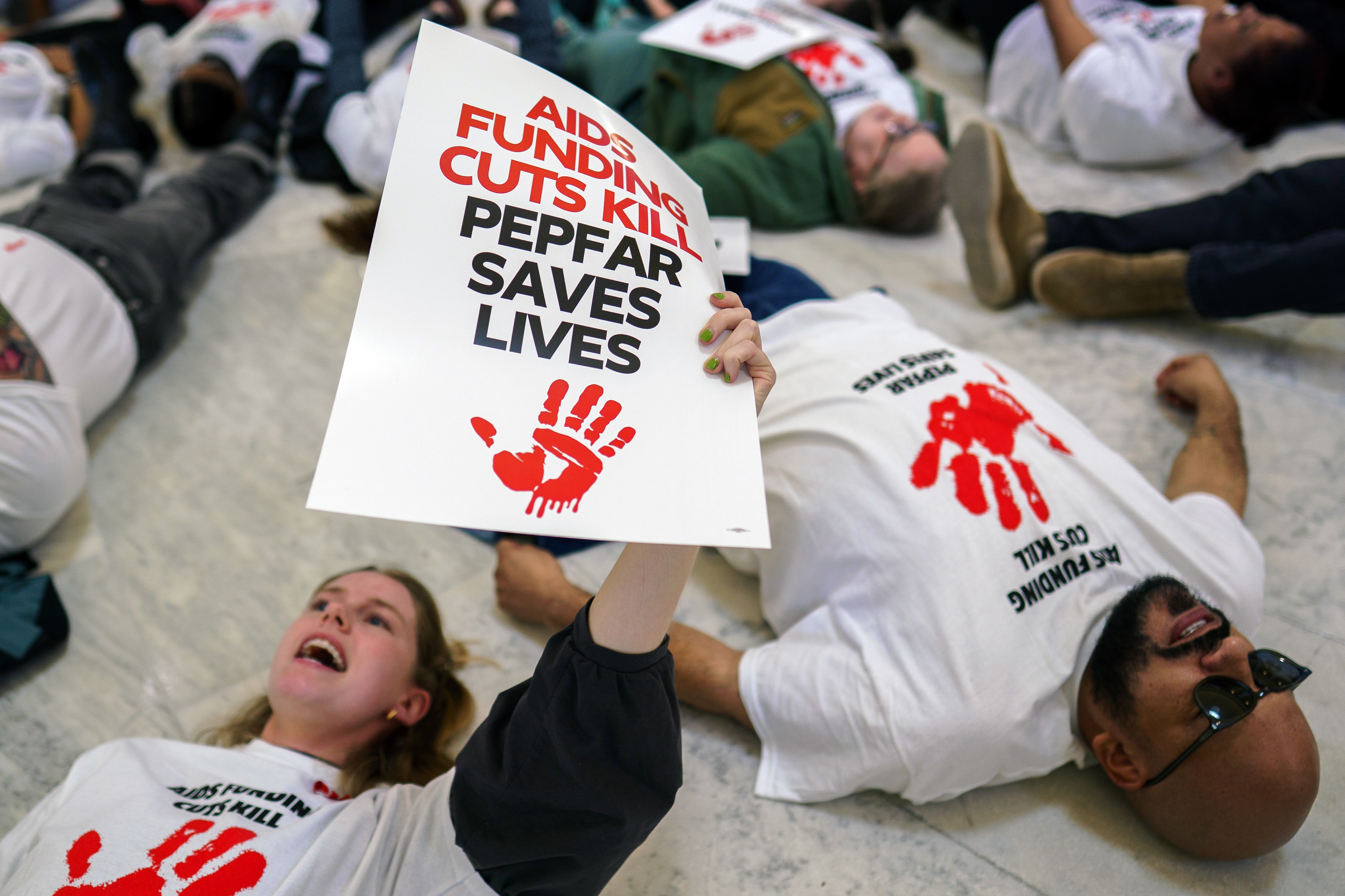 Protesters participate in a 'die in' in the Cannon Building of the US Capitol in Washington, DC, USA, 26 February 2025. The group was protesting cuts to USAID's Pepfar program, a US government program designed to tackle the spread of HIV/AIDs.  EPA-EFE/WILL OLIVER