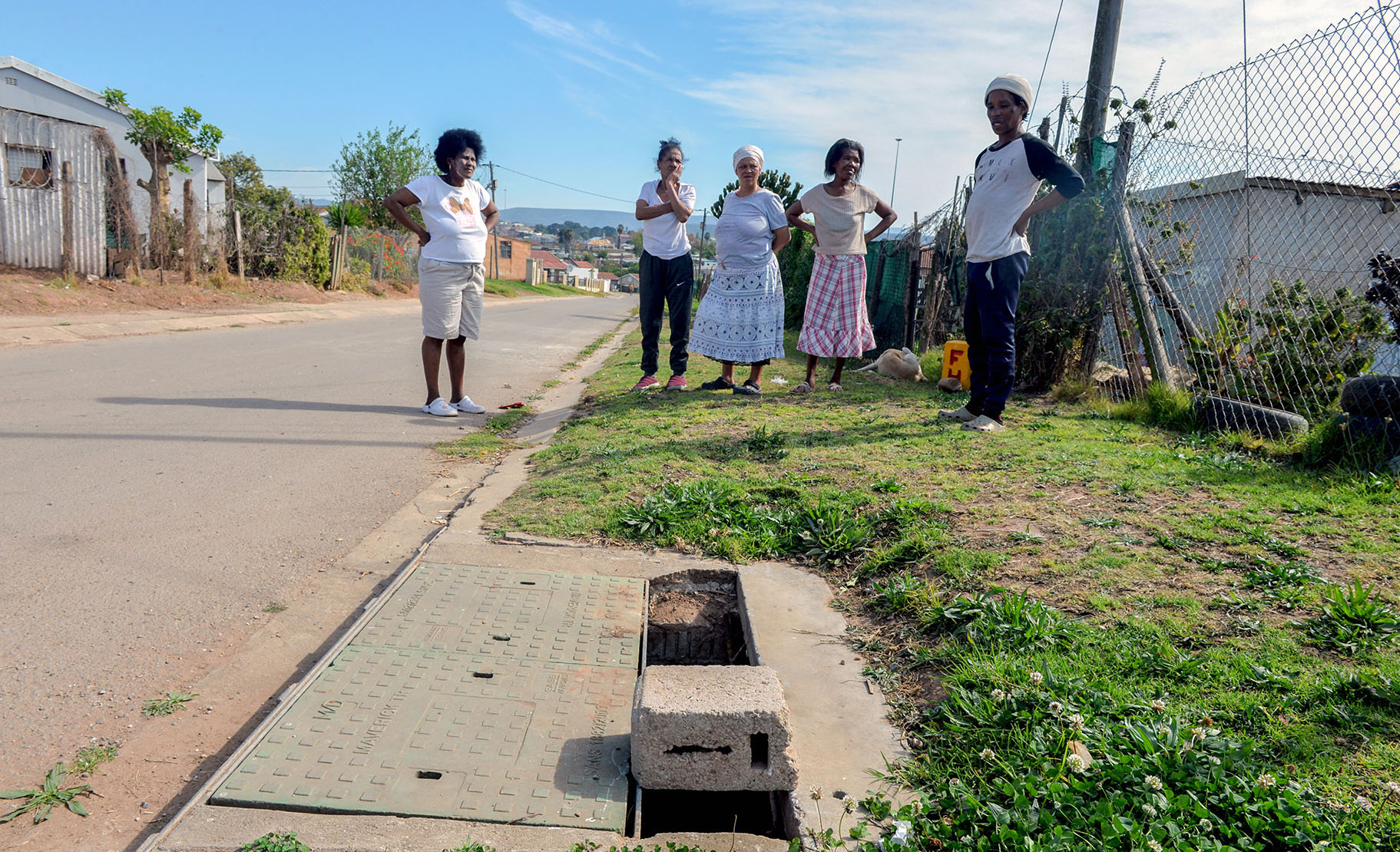 Residents of Grootboom Street, where a toddler drowned in a broken drain in September 2014. While the drain was fixed in 2021, part of the cover has once again been vandalised. (Photo: Deon Ferreira)