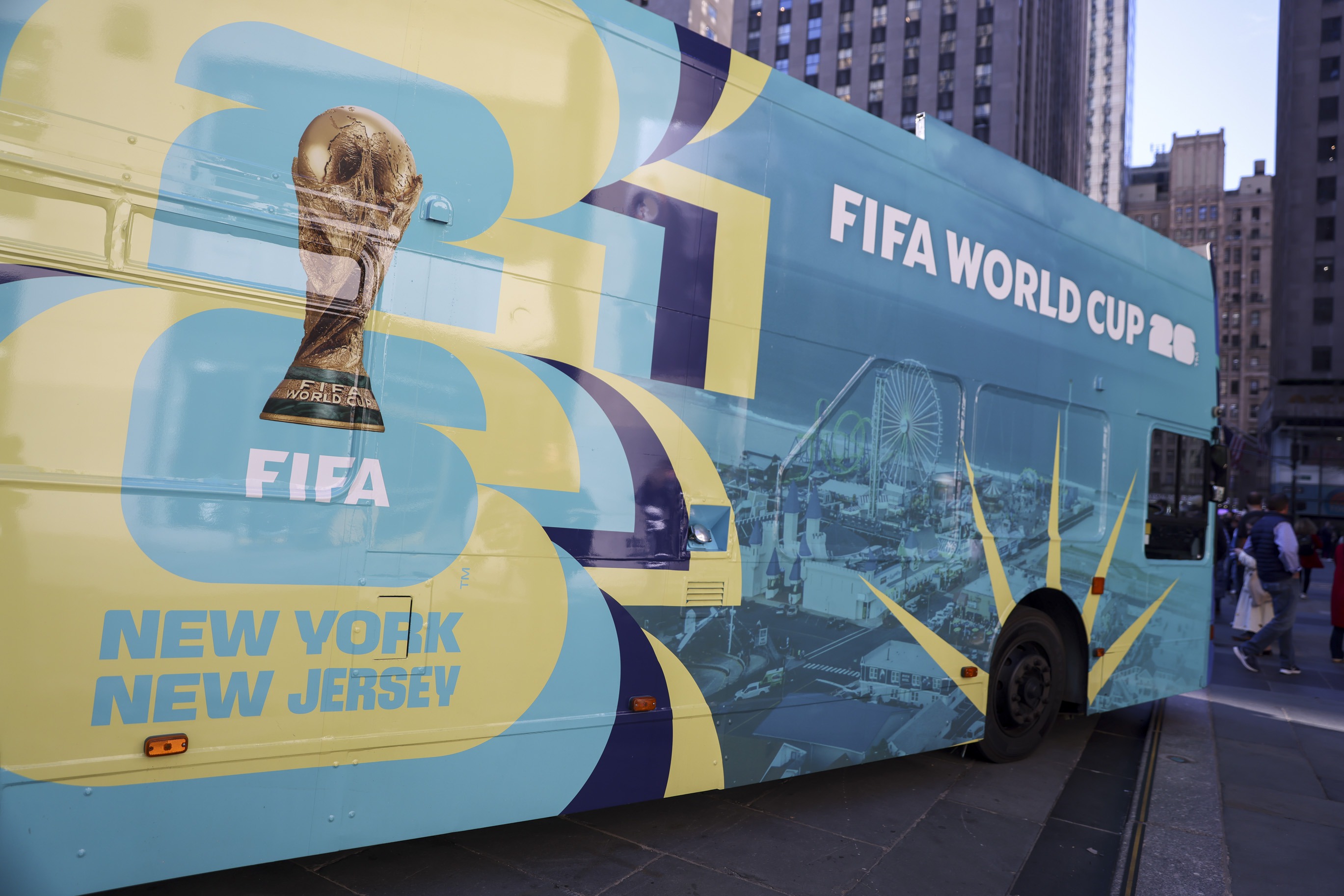 epa12475829 People view the FIFA World Cup 26 NY/NJ bus during a press conference to unveil plans for the New York/New Jersey FIFA World Cup Fan Village at Rockefeller Center in New York, New York, USA, 23 October 2025.  EPA/SARAH YENESEL