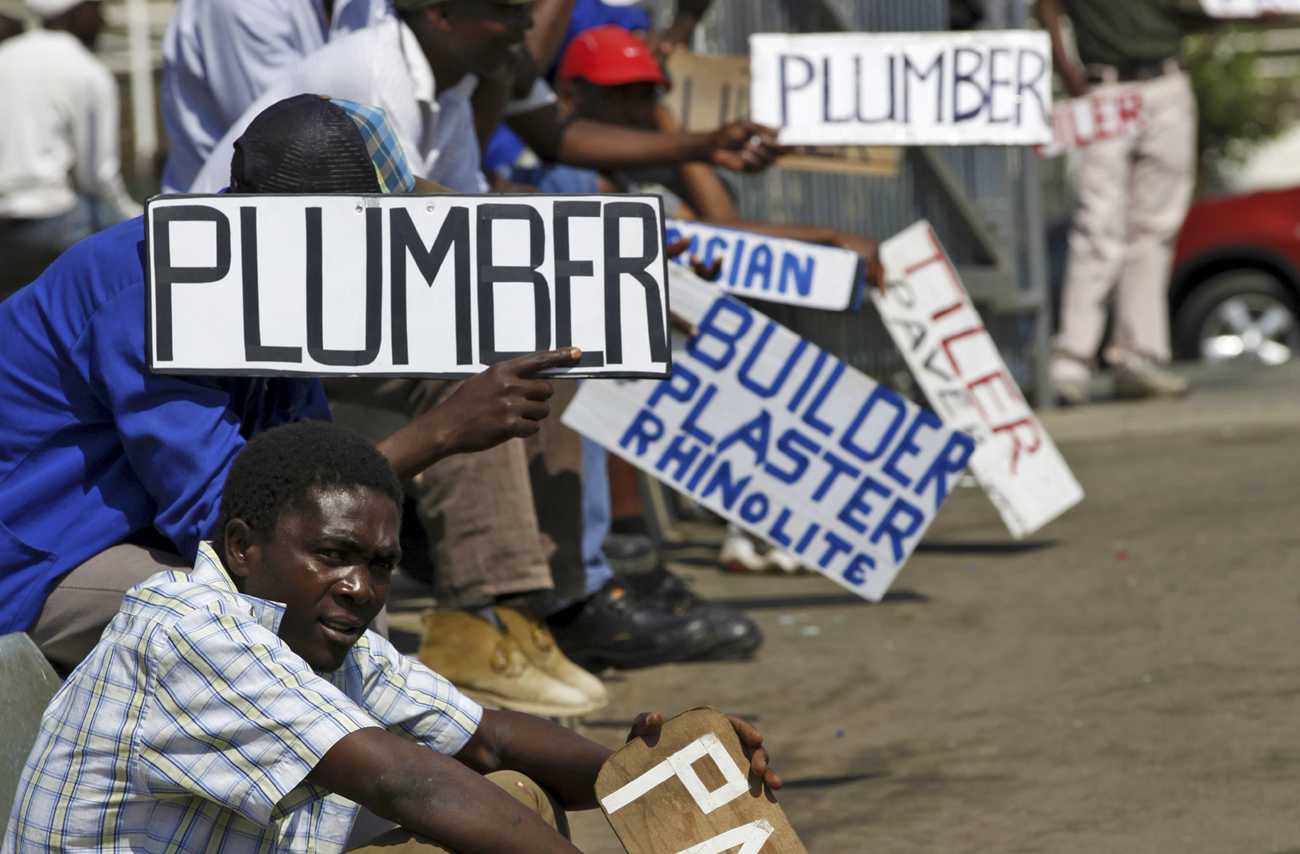 Men hold placards offering temporal employment services in Glenvista