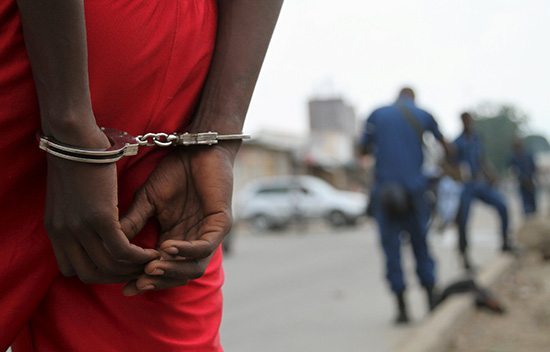 A suspect is handcuffed and detained by policemen after a grenade attack of Burundi's capital Bujumbura