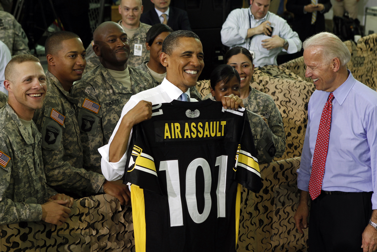 U.S. President Barack Obama holds up a shirt for the 101 Airborne after speaking to troops at Fort Campbell in Kentucky