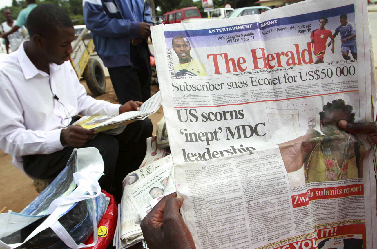 Zimbabweans read copies of the state owned newspaper on the streets of Harare