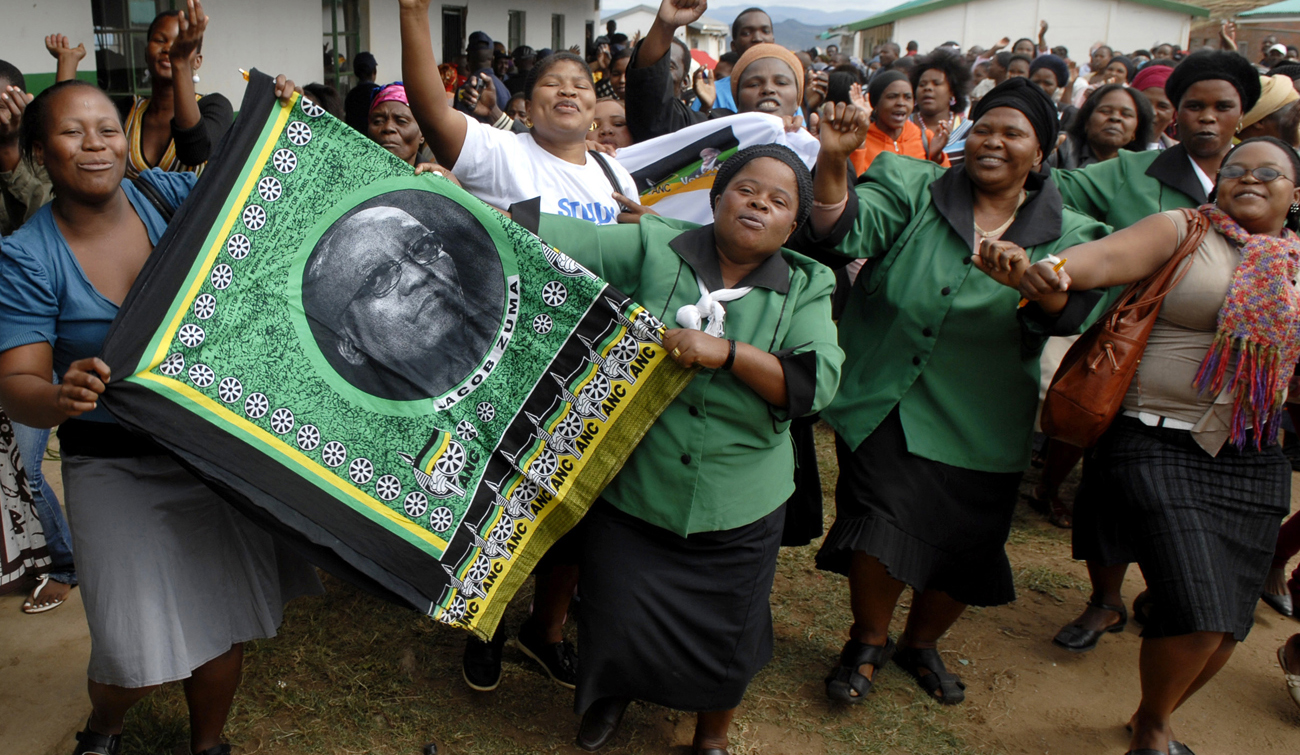 Supporters of South Africa's ruling ANC leader Jacob Zuma sing party songs as he enters the voting station in Nkandla