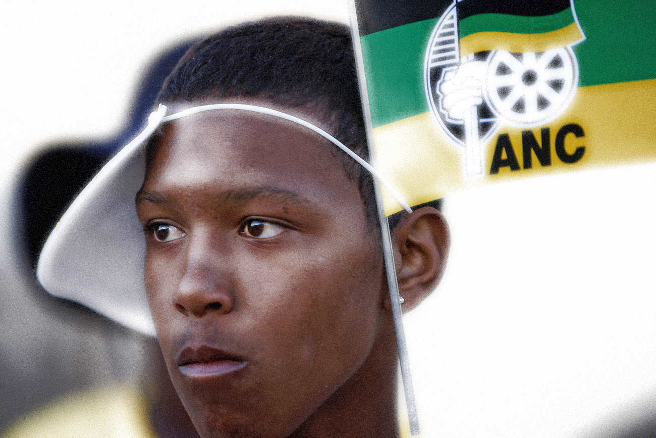 A youth is adorned with flags of the ruling African National Congress (ANC) during an election campaign event in Cape Town's Mitchells' Plain township