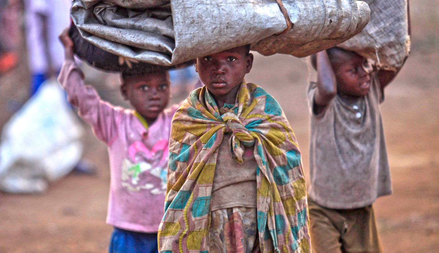 Displaced Congolese families trek back into the Democratic Republic of Congo after spending a night across the border in Uganda in Bunagana