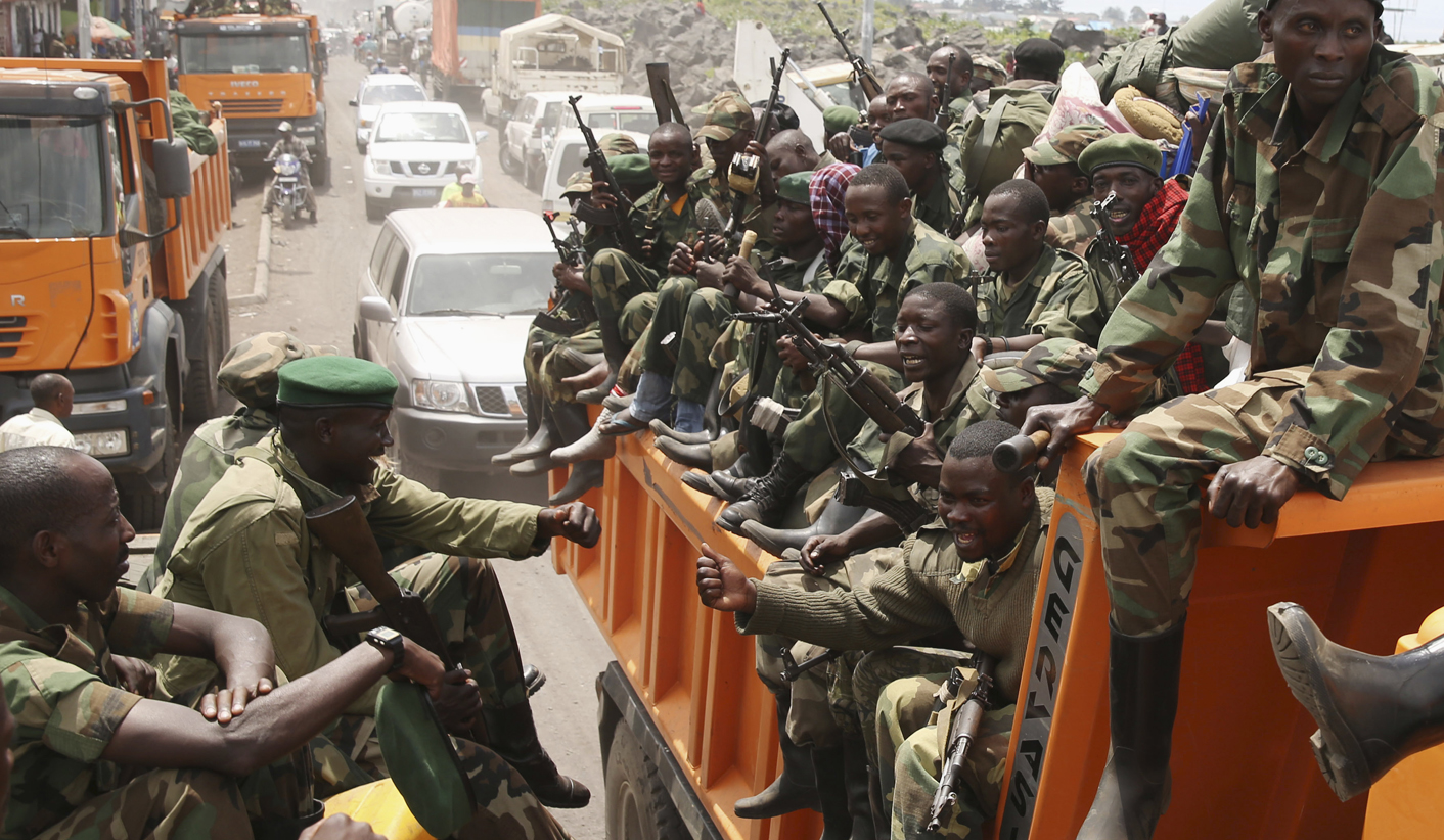 M-23 rebel fighters are transported on trucks as they withdraw from Goma