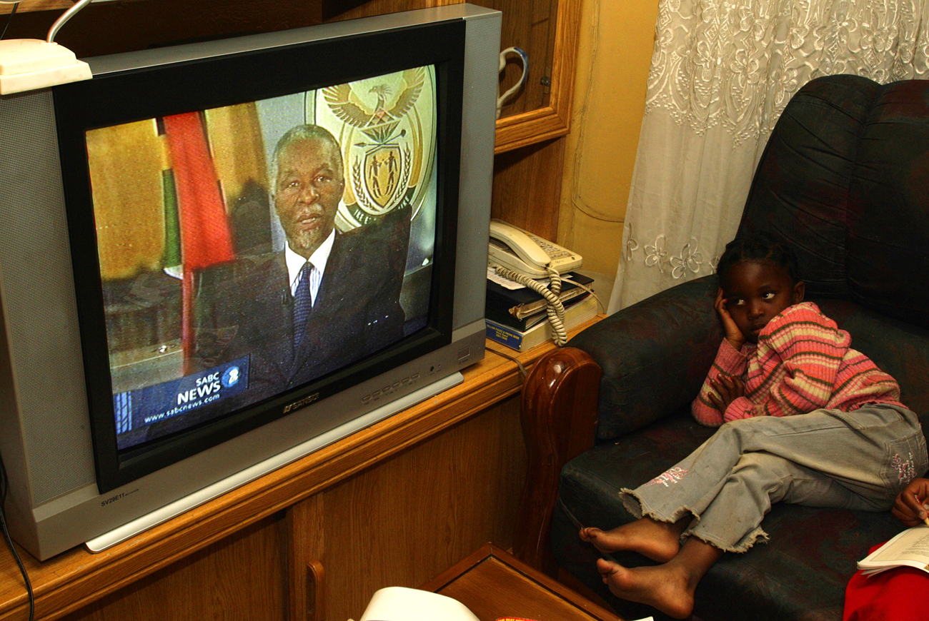 A girl watches as deposed South African President Mbeki addresses the nation, on national broadcaster SABC, in Johannesburg