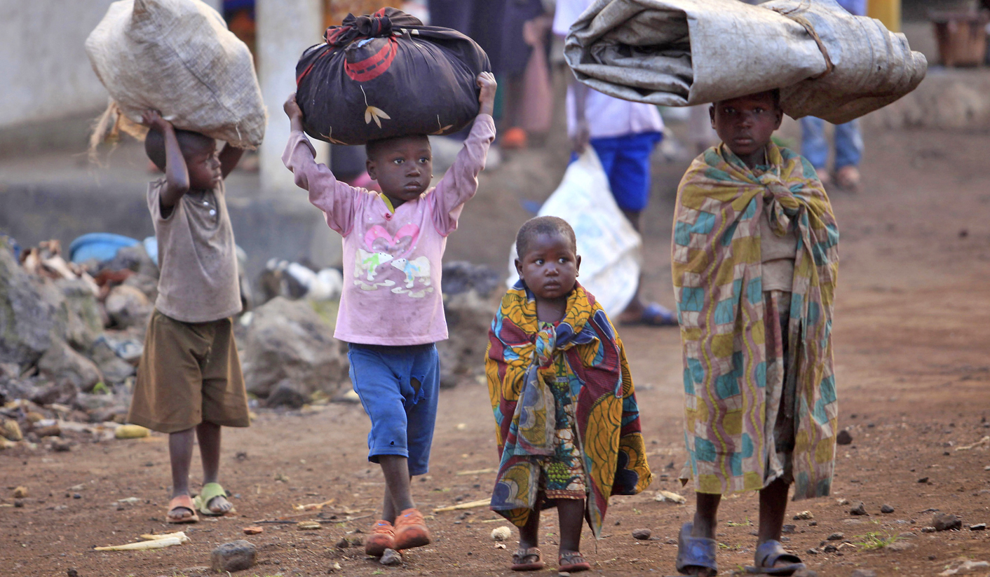 Displaced Congolese families trek back into the Democratic Republic of Congo after spending a night across the border in Uganda in Bunagana