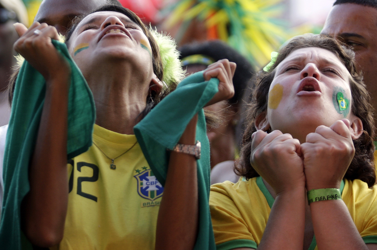 Brazilian soccer fans react while watching the FIFA World Cup soccer match between Brazil and Chile, on Copacabana beach in Rio de Janeiro