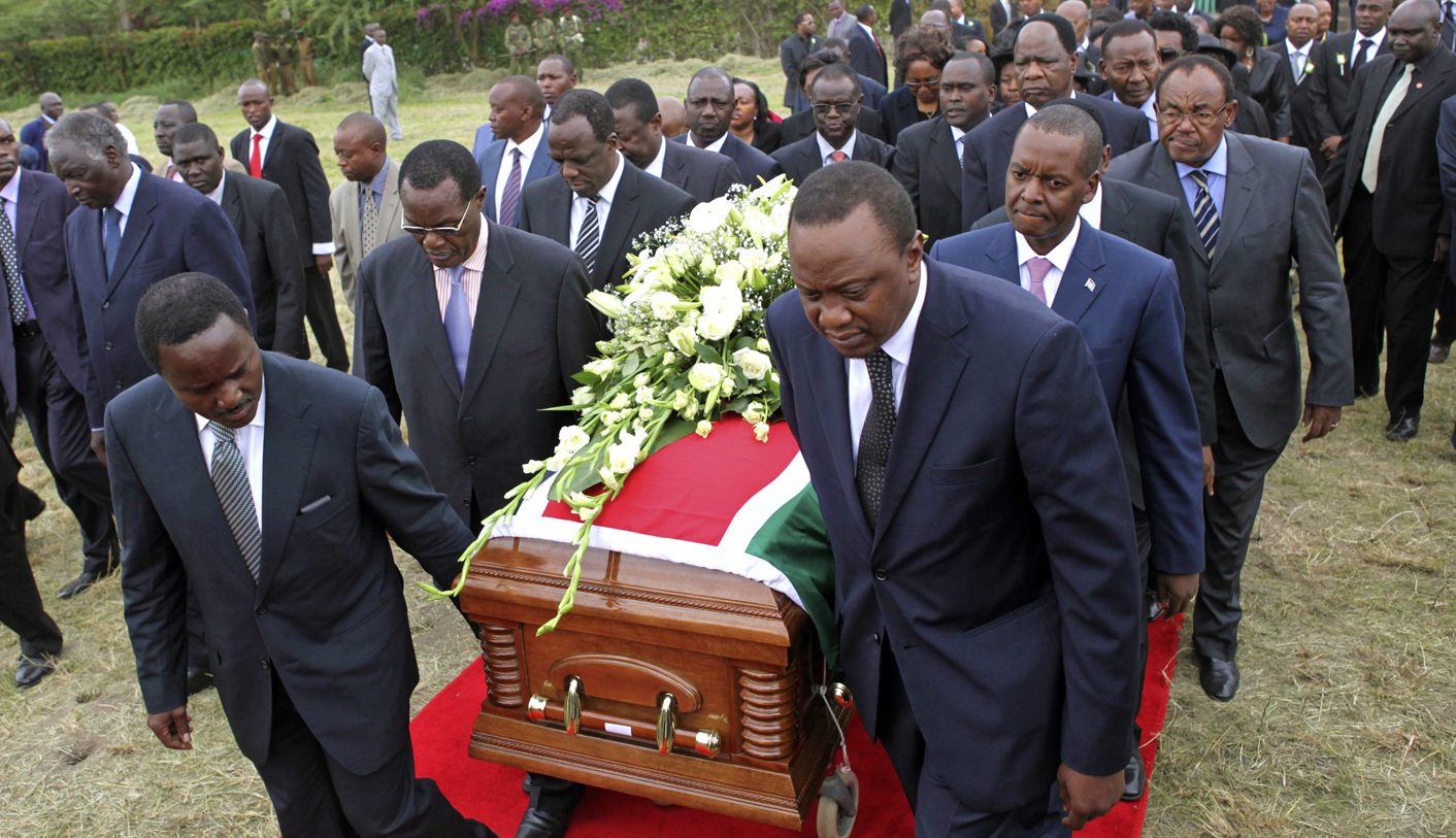 Cabinet officials wheel the coffin of Kenya's internal security minister Saitoti during his burial ceremony at his farm in Kitengela