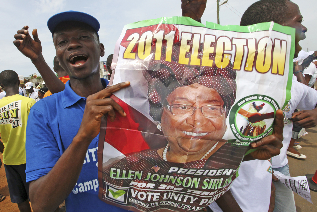 Supporters of Nobel Peace Prize laureate and Liberian President Ellen Johnson-Sirleaf cheer and hold posters of her during her campaign rally in Monrovia