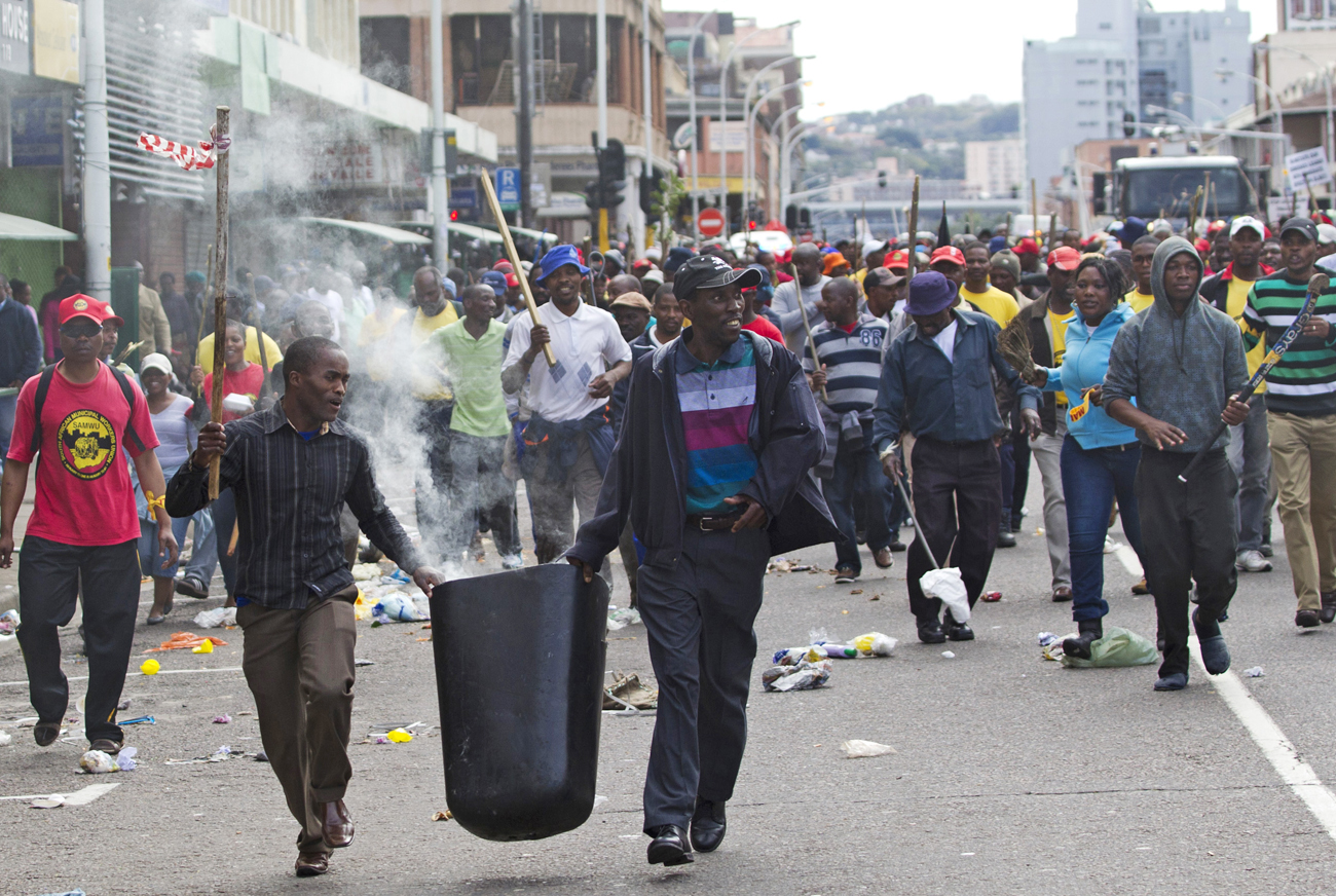 Striking workers of the SAMWU march through Durban disposing garbage into the streets and setting rubbish bins on fire