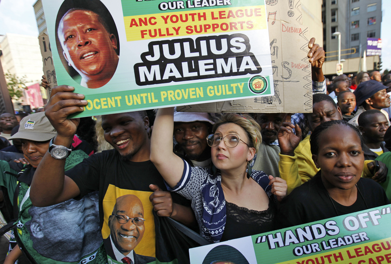 Supporters of ANCYL President Malema hold placards during his appearance at the Johannesburg court