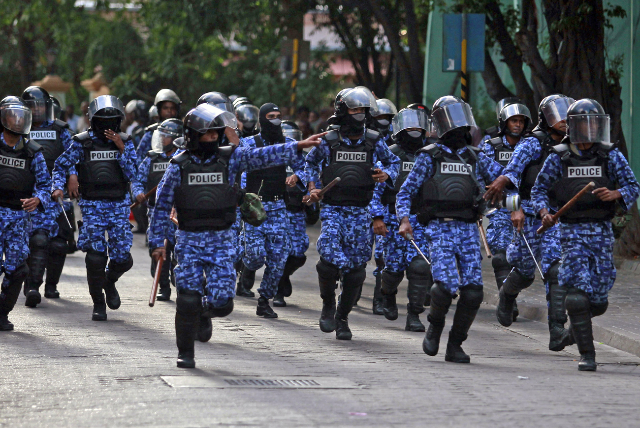 Maldivian riot police chase away the supporters of the ousted Maldivian president Mohamed Nasheed during a clash in Male