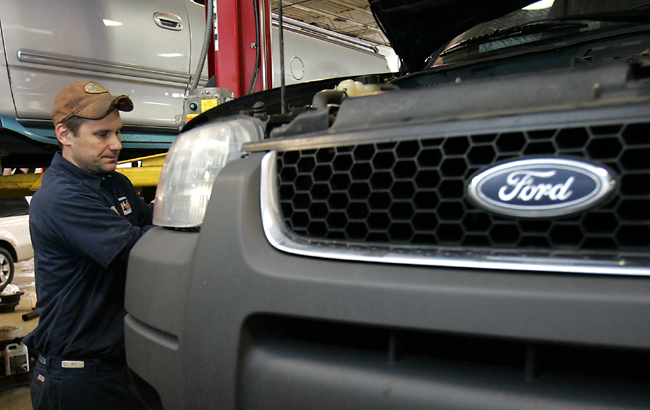 Auto mechanic Paul Cook works on a customer's Ford Escape SUV in the service department of a Ford car dealership in Warren, Michigan